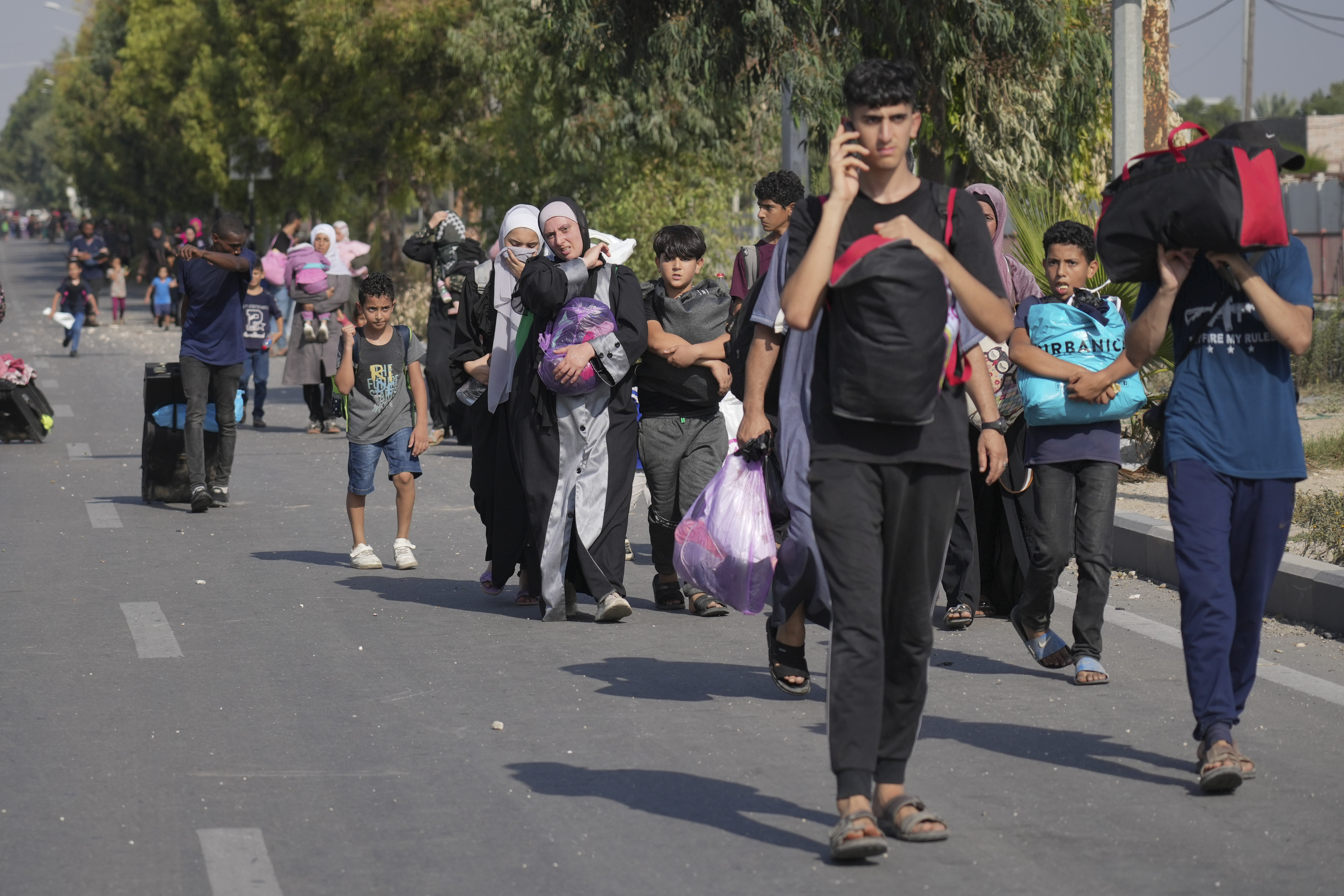 Palestinians flee the southern Gaza Strip on Salah al-Din street in Bureij on Sunday, Nov. 5