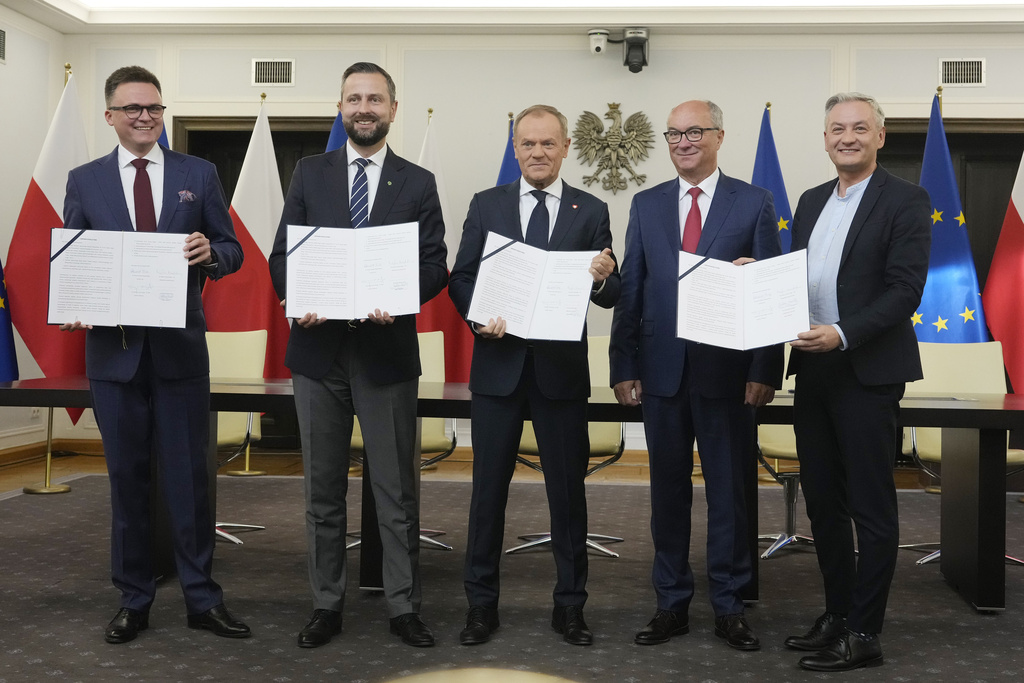 The leaders of Poland's opposition pose after signing a coalition agreement