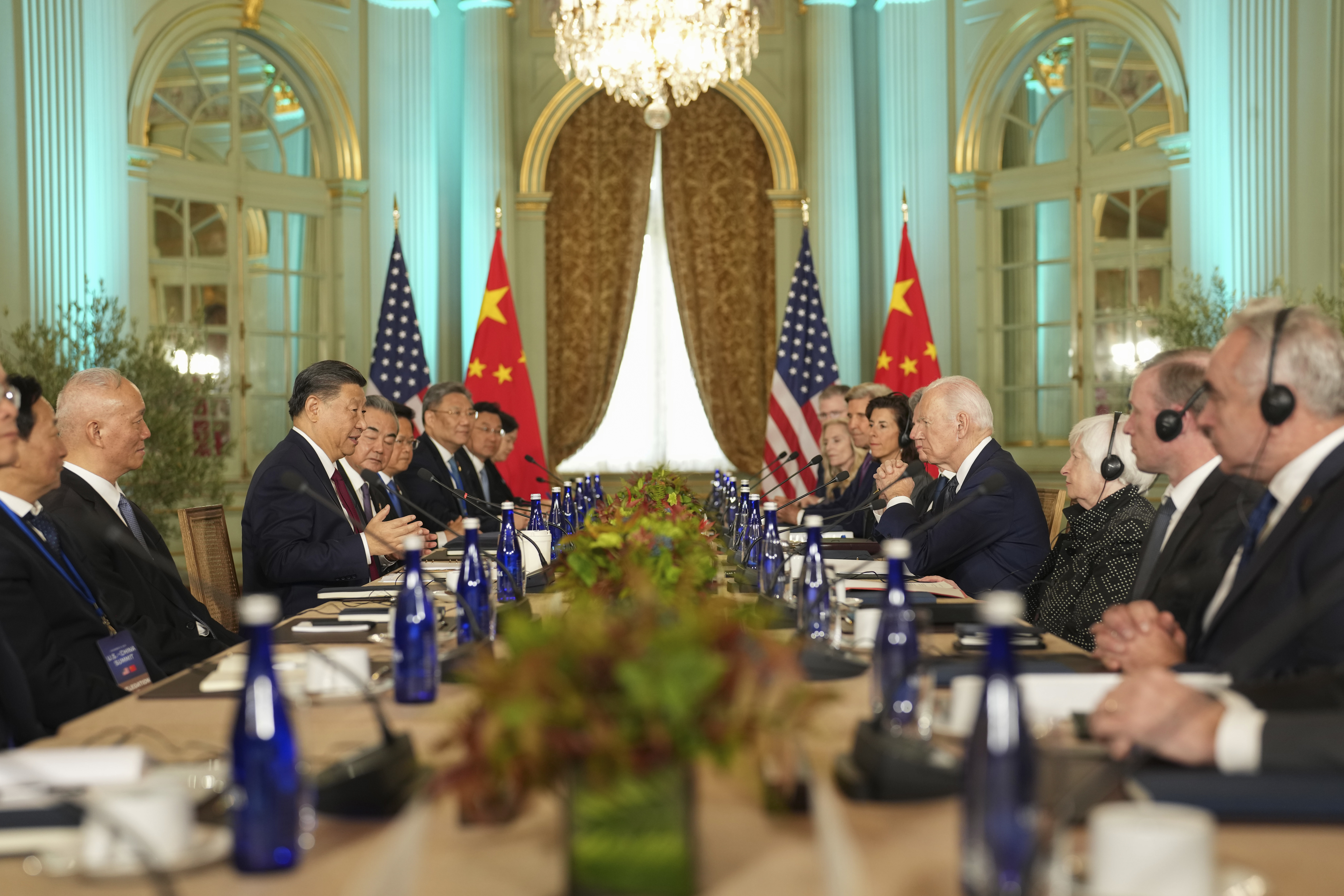 The US and Chinese delegations at their talks in California. They are facing each other across a table. Their countries' flags are at the end of the room.