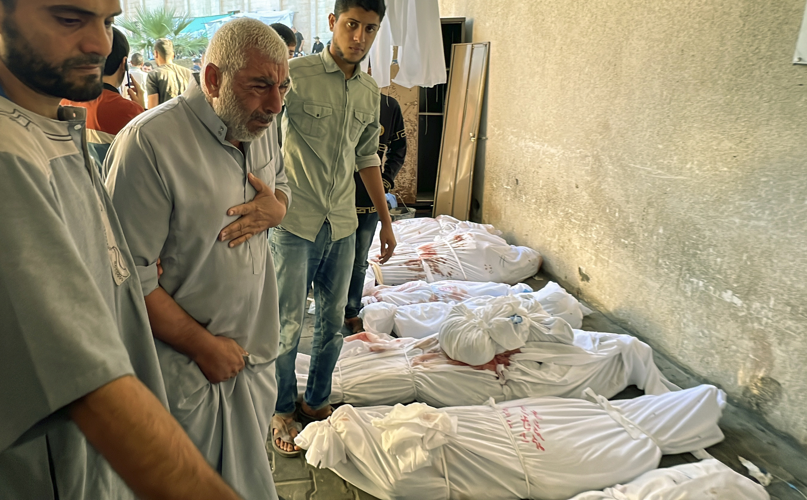 A Palestinian man reacts over the body of a relative as bodies of those killed by Israeli airstrikes on Jabaliya refugee camp are lined up, at the Indonesian hospital, northern Gaza Strip.