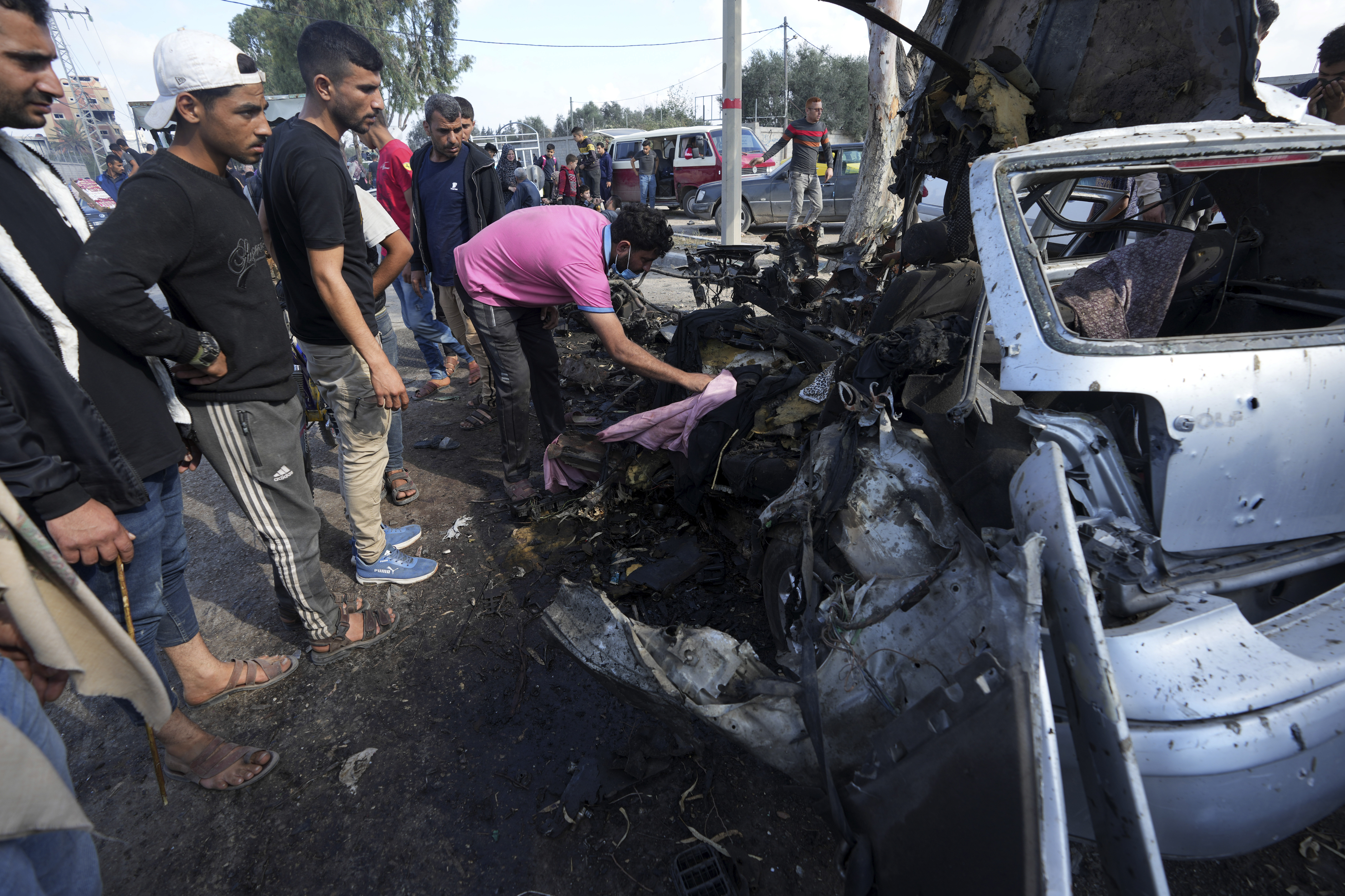 Palestinians check taxis that were hit by the Israeli military along Salah al-Din Street, on the outskirts of Gaza City.