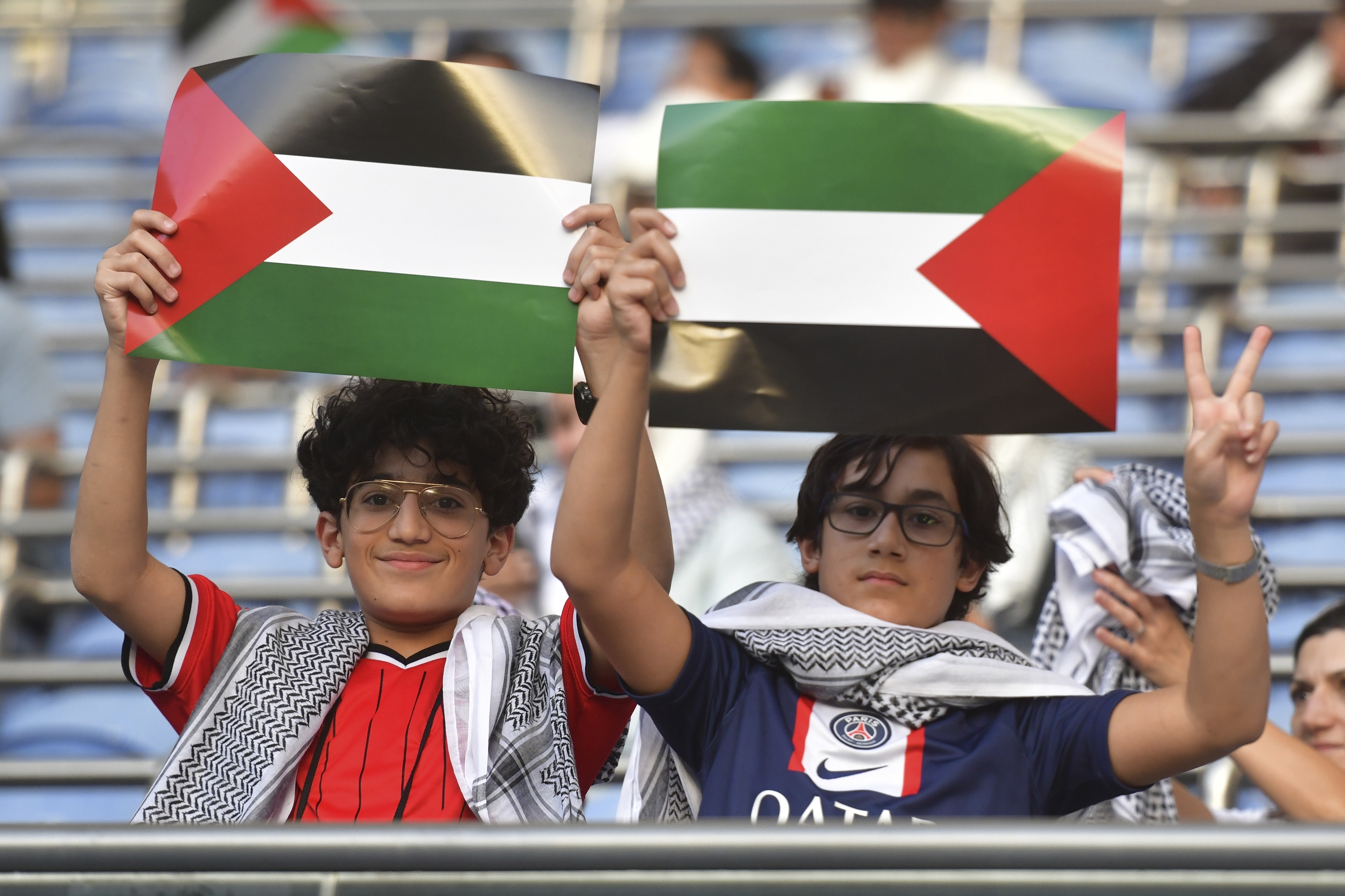 Palestinian fans hold Palestine national flags ahead of a qualifying soccer match against Australia for the FIFA World Cup 2026 at Jaber Al -Ahmad stadium in Kuwait, Tuesday, Nov. 21, 2023. (AP Photo/Jaber Abdulkhaleg)