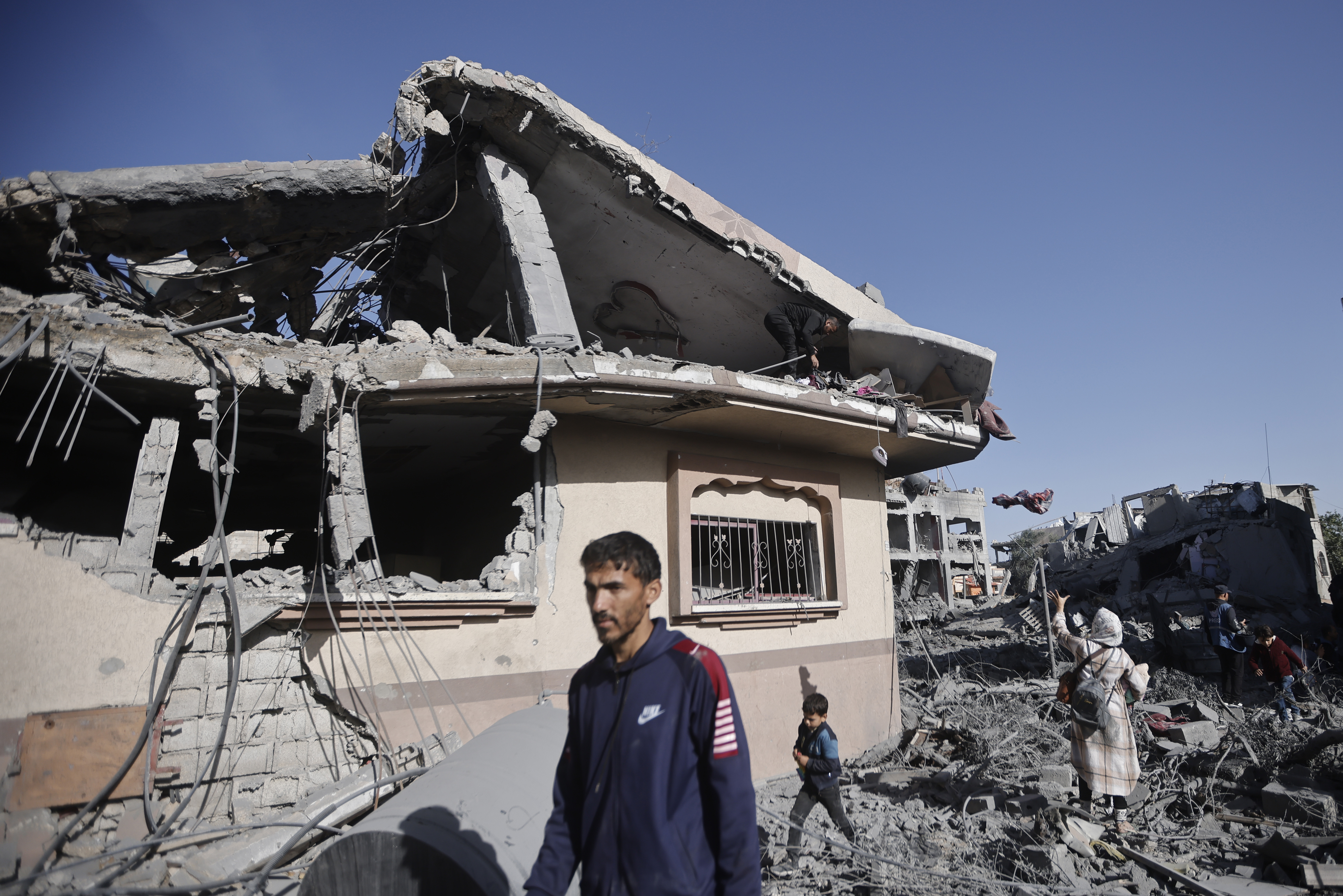 Palestinians inspect their destroyed houses in the town of Kazaa, eastern Khan Younis, southern Gaza Strip