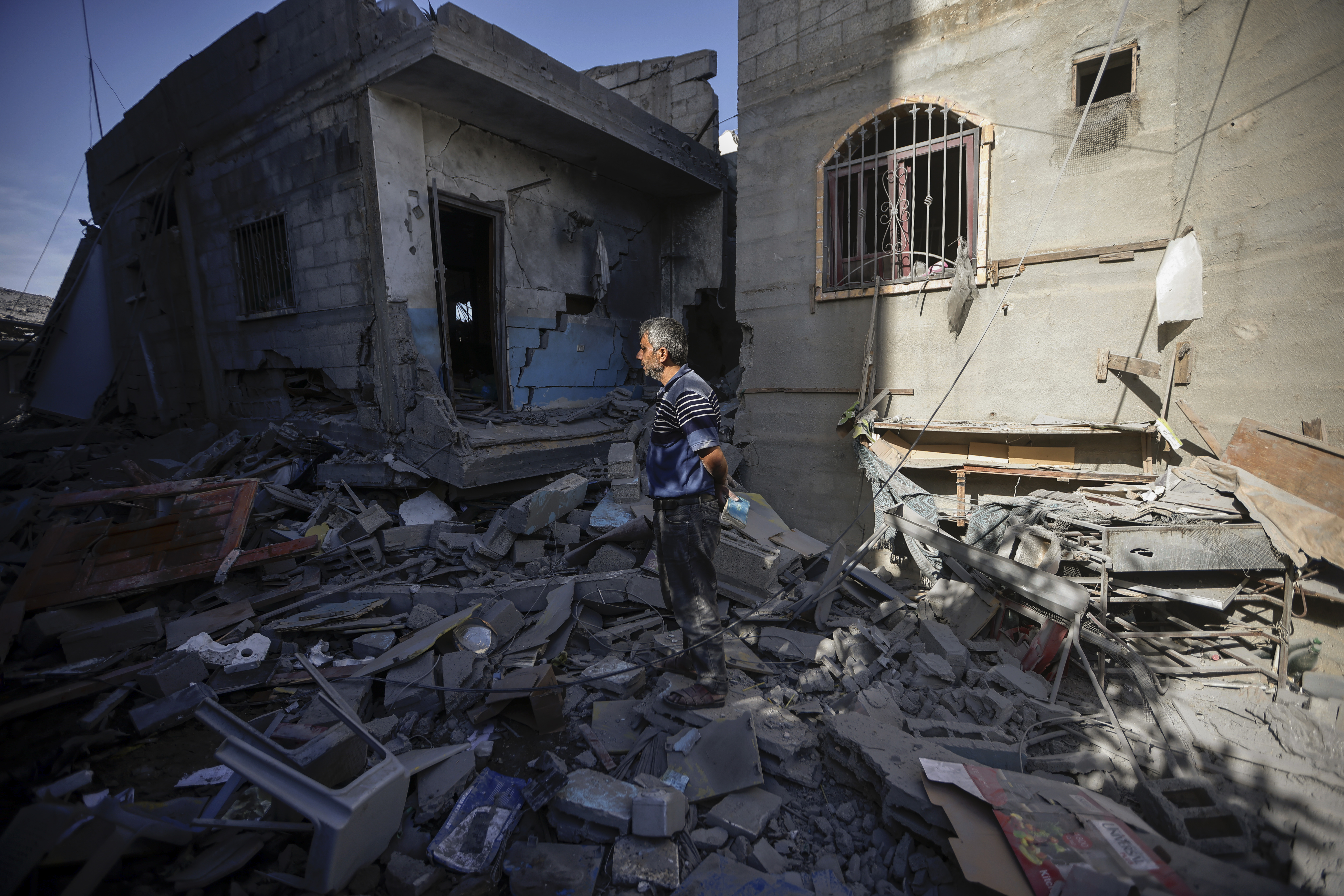 Palestinians inspect their destroyed houses in the town of Kazaa, eastern Khan Younis, southern Gaza Strip