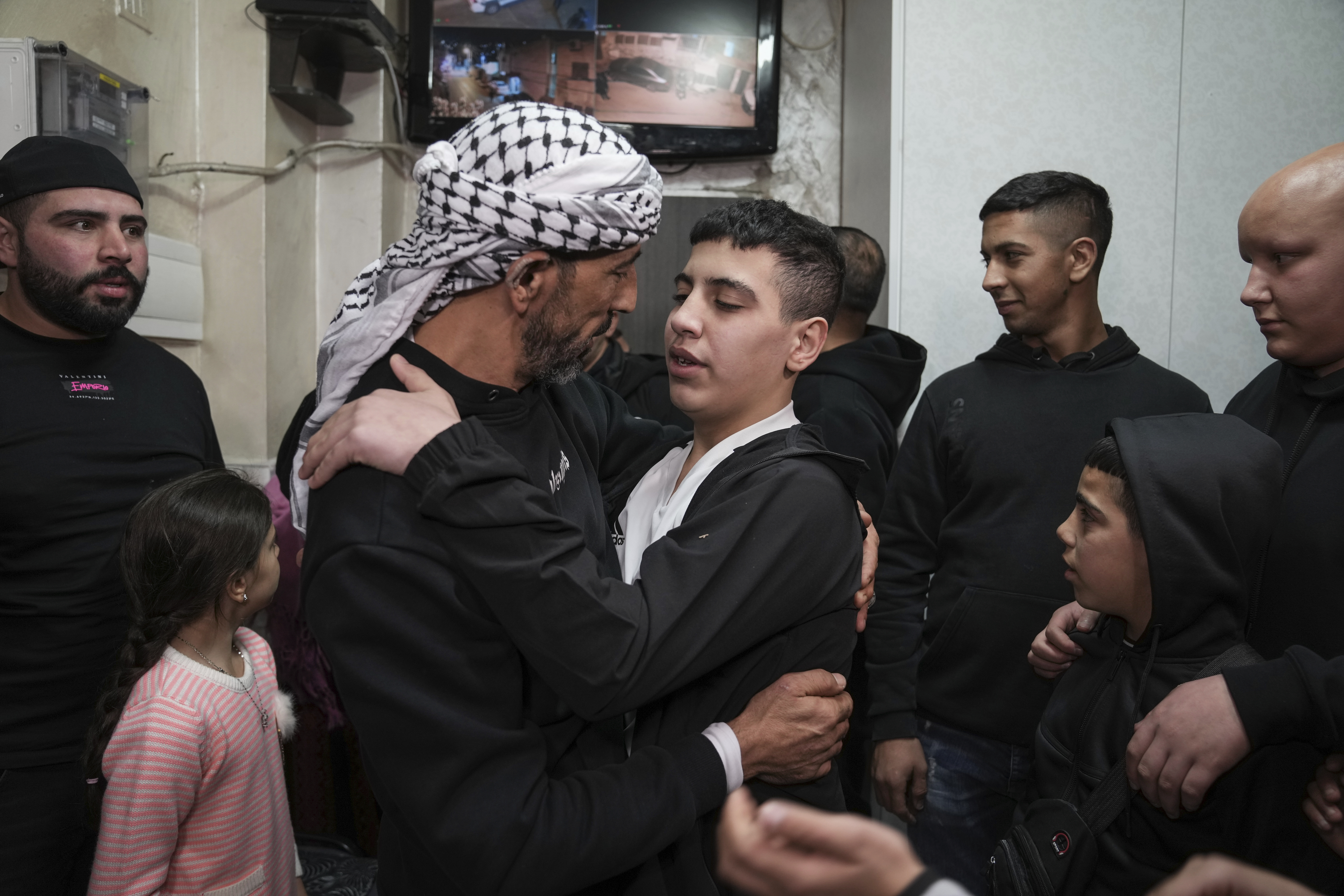 Ahmed Salaima, 14, center, a Palestinian prisoner released by Israel, is hugged by his father as he arrives home in the east Jerusalem neighborhood of Ras al-Amud.