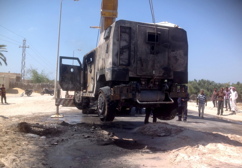 A burned armoured car being lifted