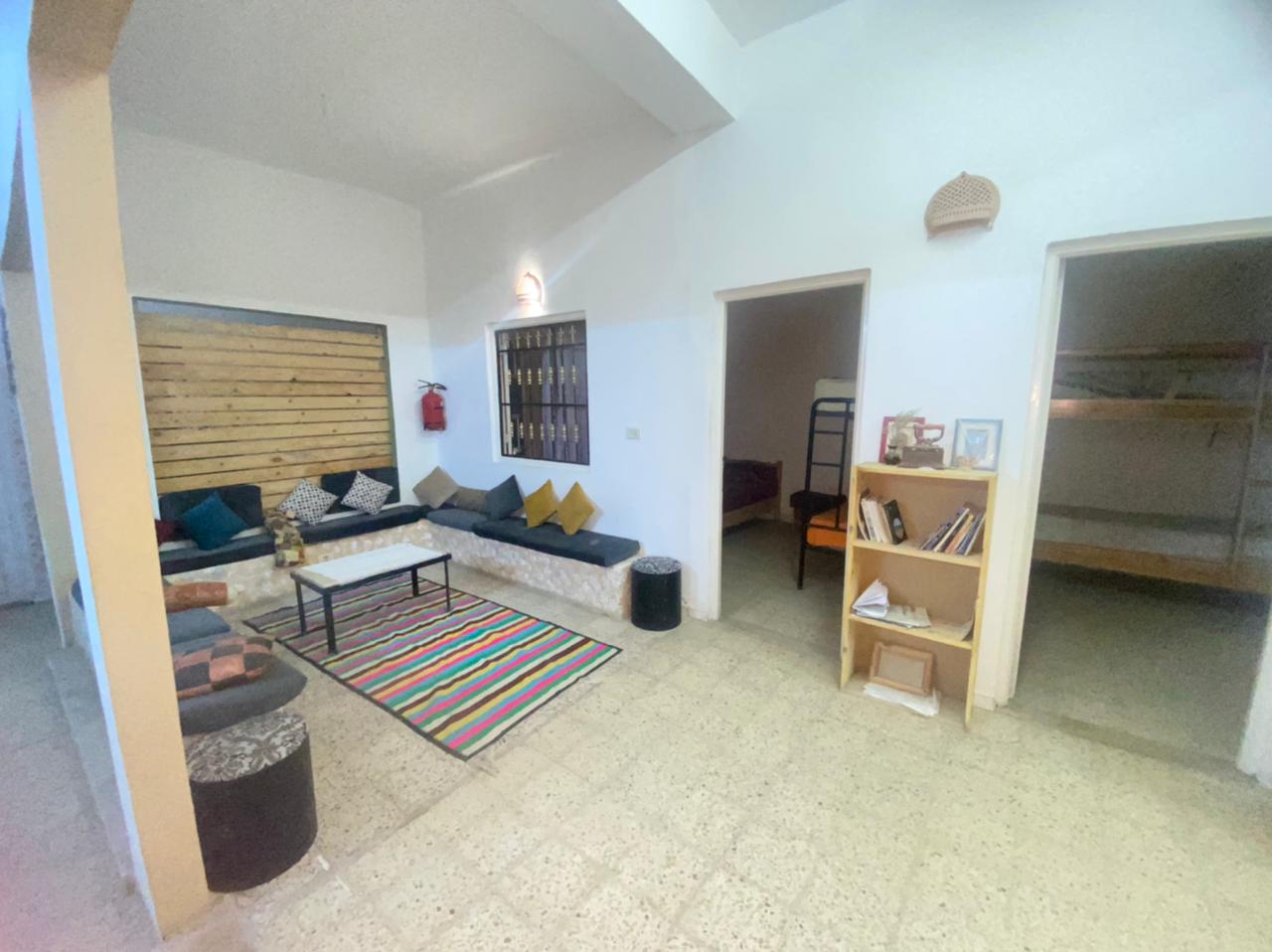 A photo of the inside of a house with a living room and two rooms with bunkbeds.