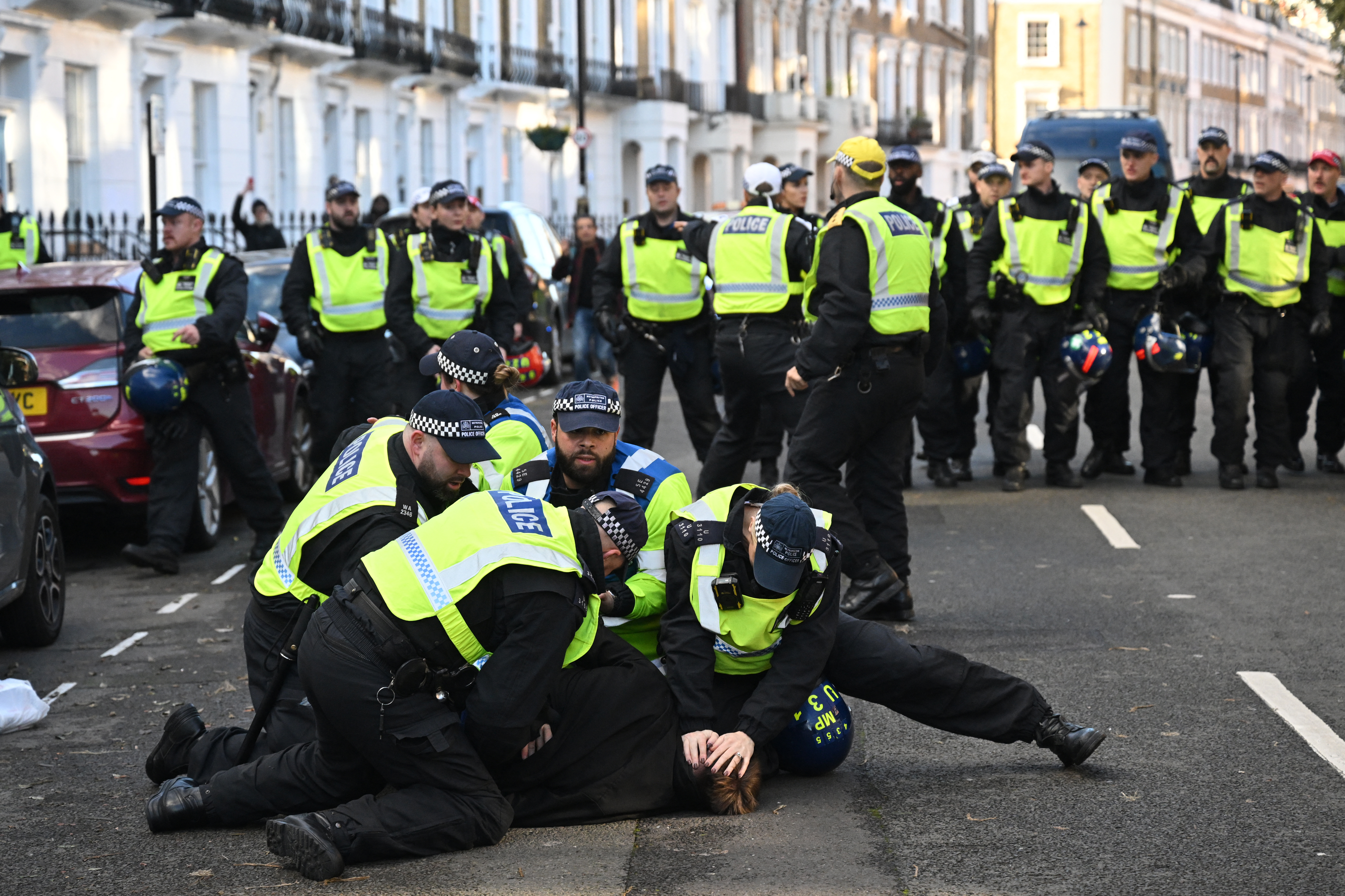 Police officers detain a man in the street close to the 'National March For Palestine' in central London on November 11, 2023, as counter-protest groups are monitored by police close to the route of the main march. [JUSTIN TALLIS / AFP]
