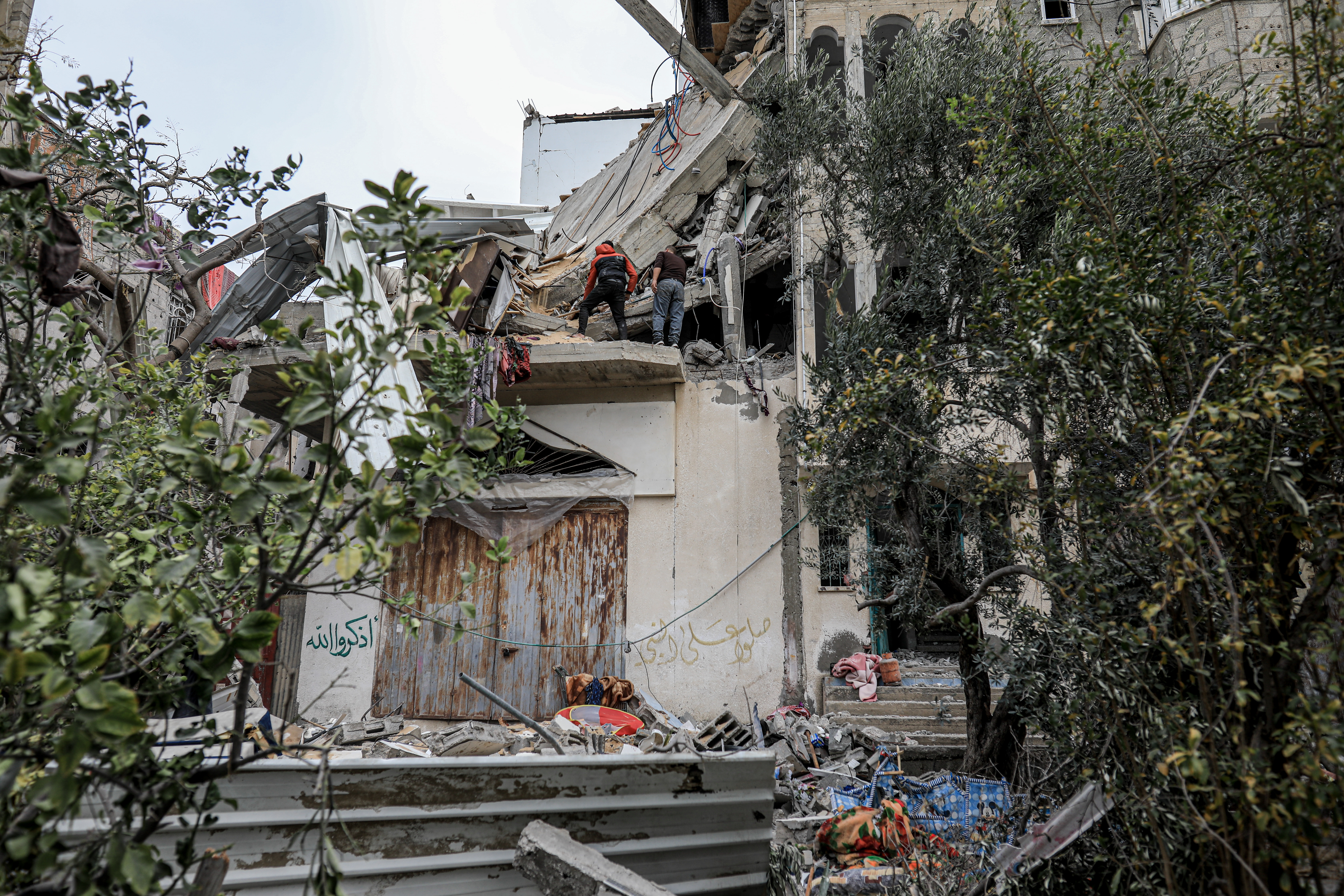 Relatives and people check the destruction aftermath the bombing