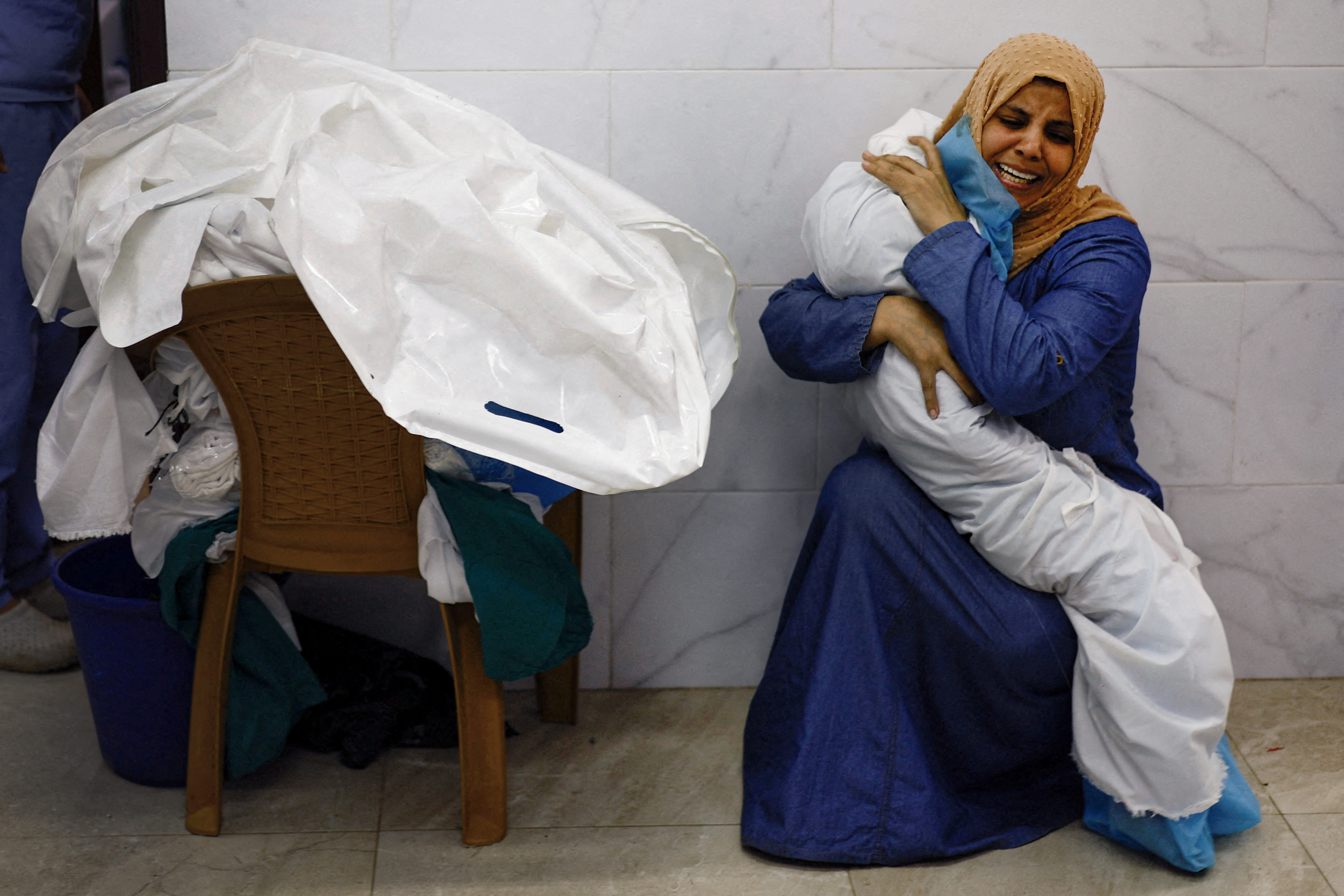 Palestinian woman Inas Abu Maamar, 36, embraces the body of her 5-year-old niece Saly, who was killed in an Israeli strike, at Nasser hospital in Khan Younis in the southern Gaza Strip, October 17, 2023. Reuters photographer Mohammad Salem was in Khan Younis on Oct. 17 at the Nasser Hospital morgue.