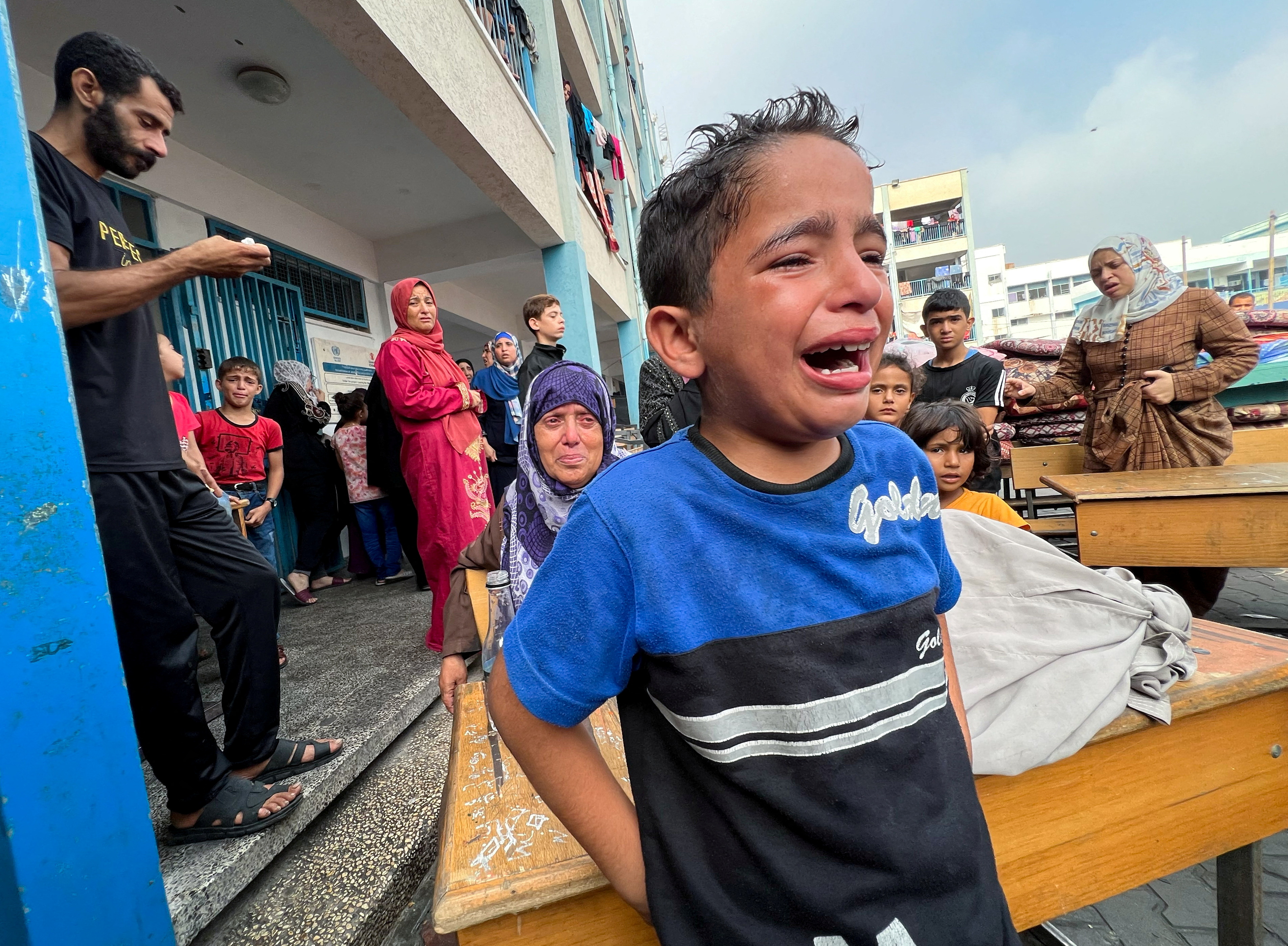 A Palestinian boy reacts at the damages at a UN-run school sheltering displaced people, following an Israeli strike, in Jabalia in the northern Gaza Strip.