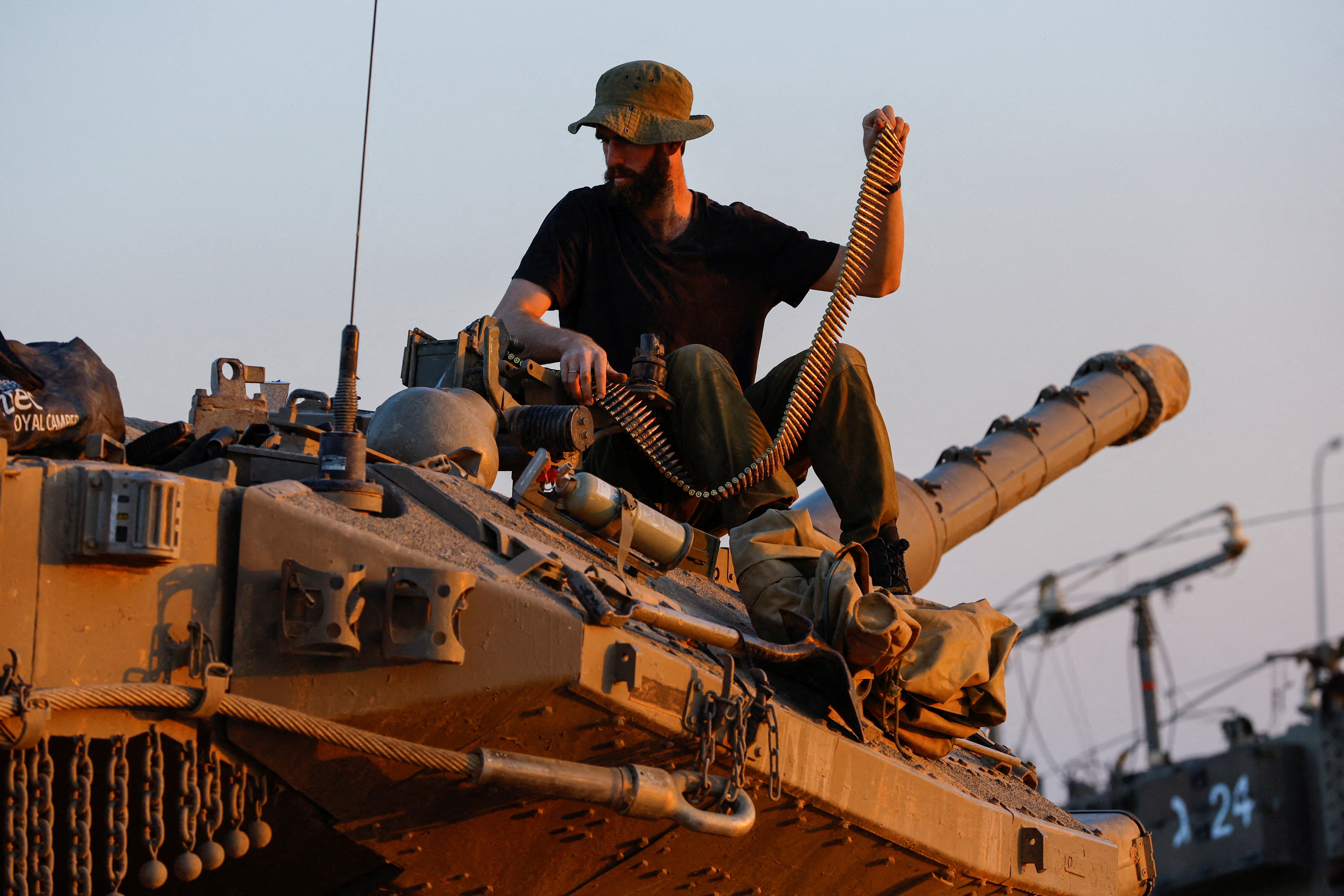 An Israeli soldier reloads the machine gun of tank Merkava, amid a temporary truce between Hamas and Israel, near Gaza, in South Israel, November 30, 2023. REUTERS/Alexander Ermochenko TPX IMAGES OF THE DAY