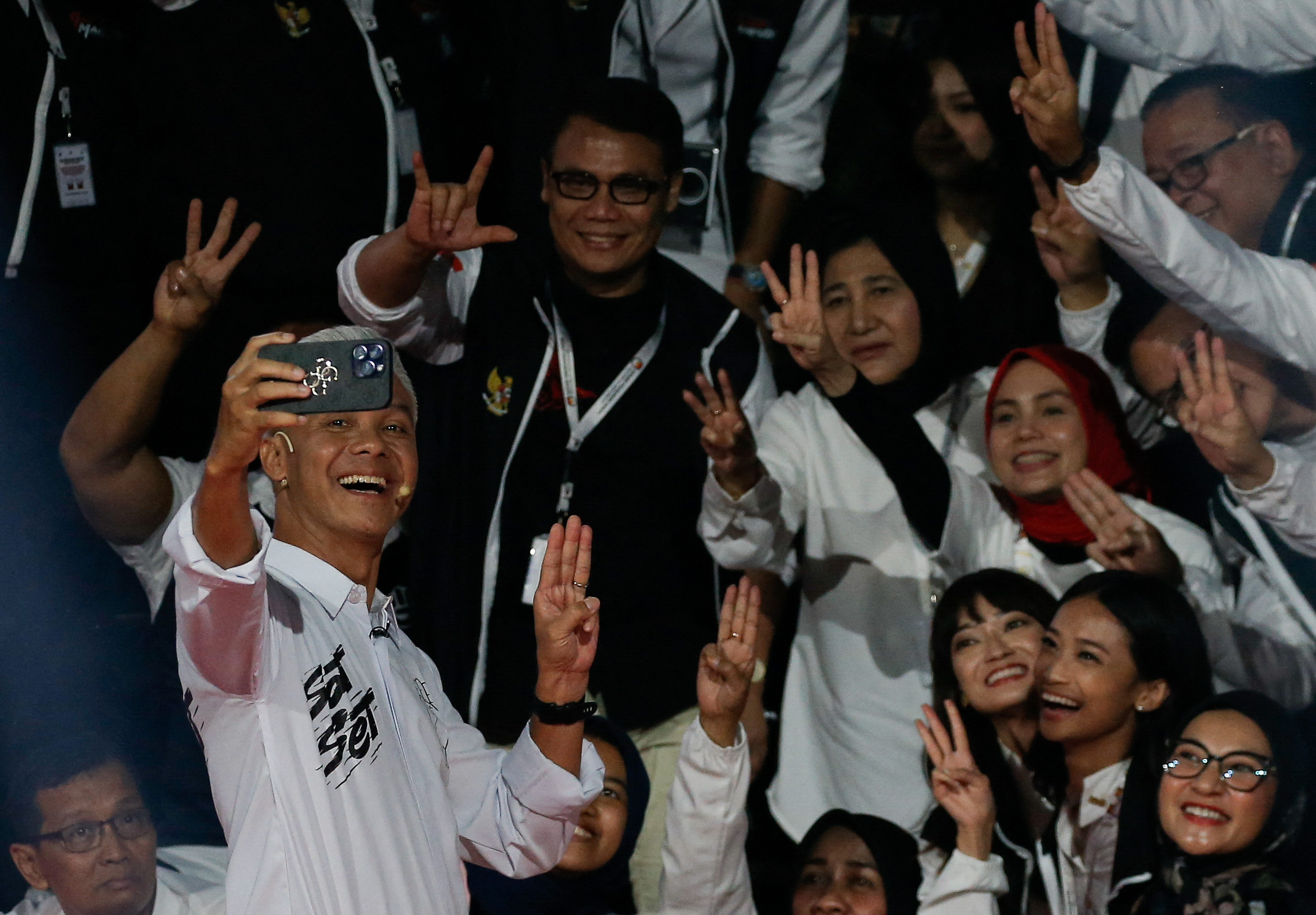 Ganjar taking a selfie with supporters at the debate