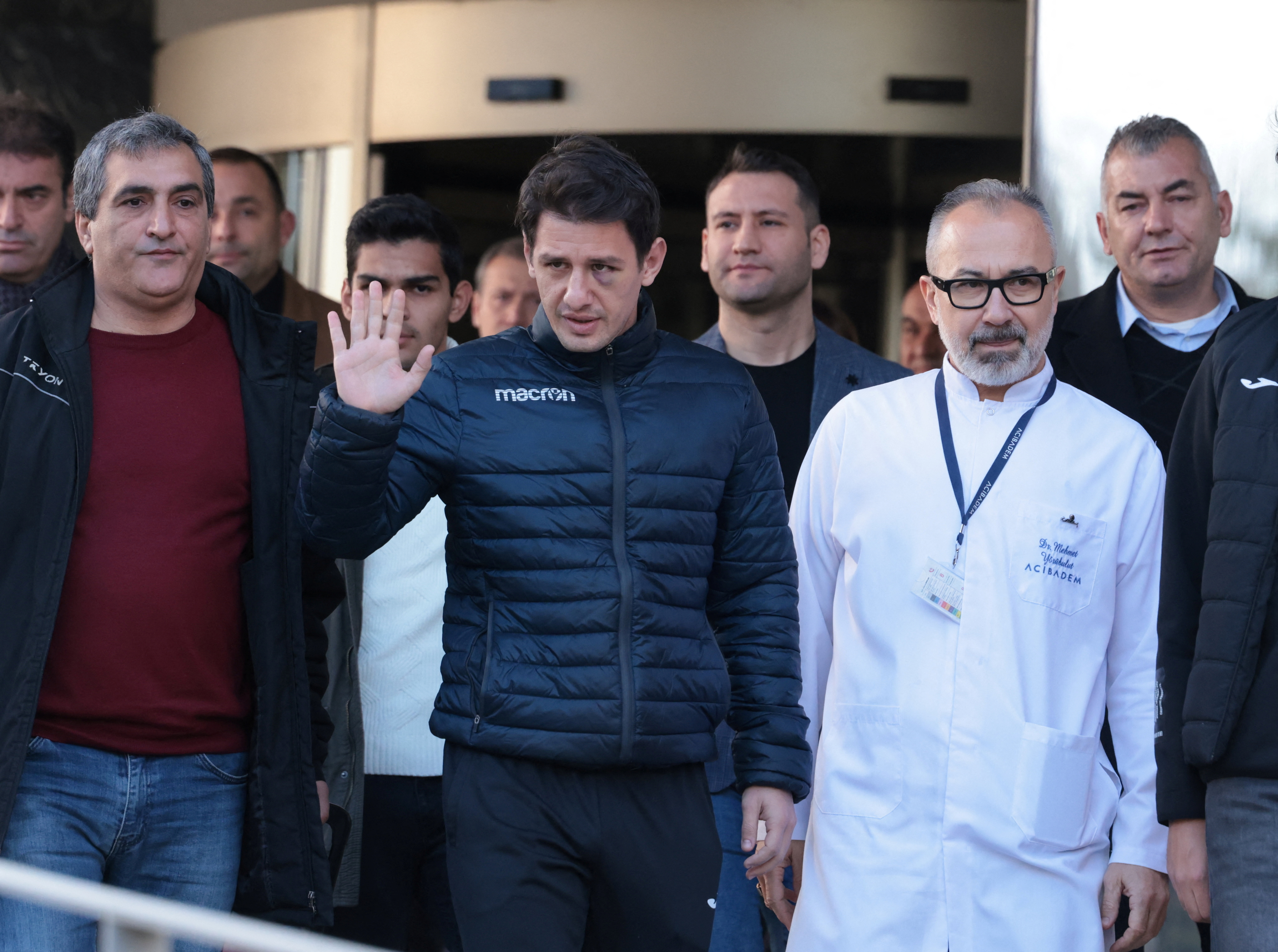 Turkish referee Halil Umut Meler, accompanied by head doctor Mehmet Yorubulut, greets media members as he leaves from a hospital in Ankara, Turkey December 13, 2023. REUTERS/Cagla Gurdogan