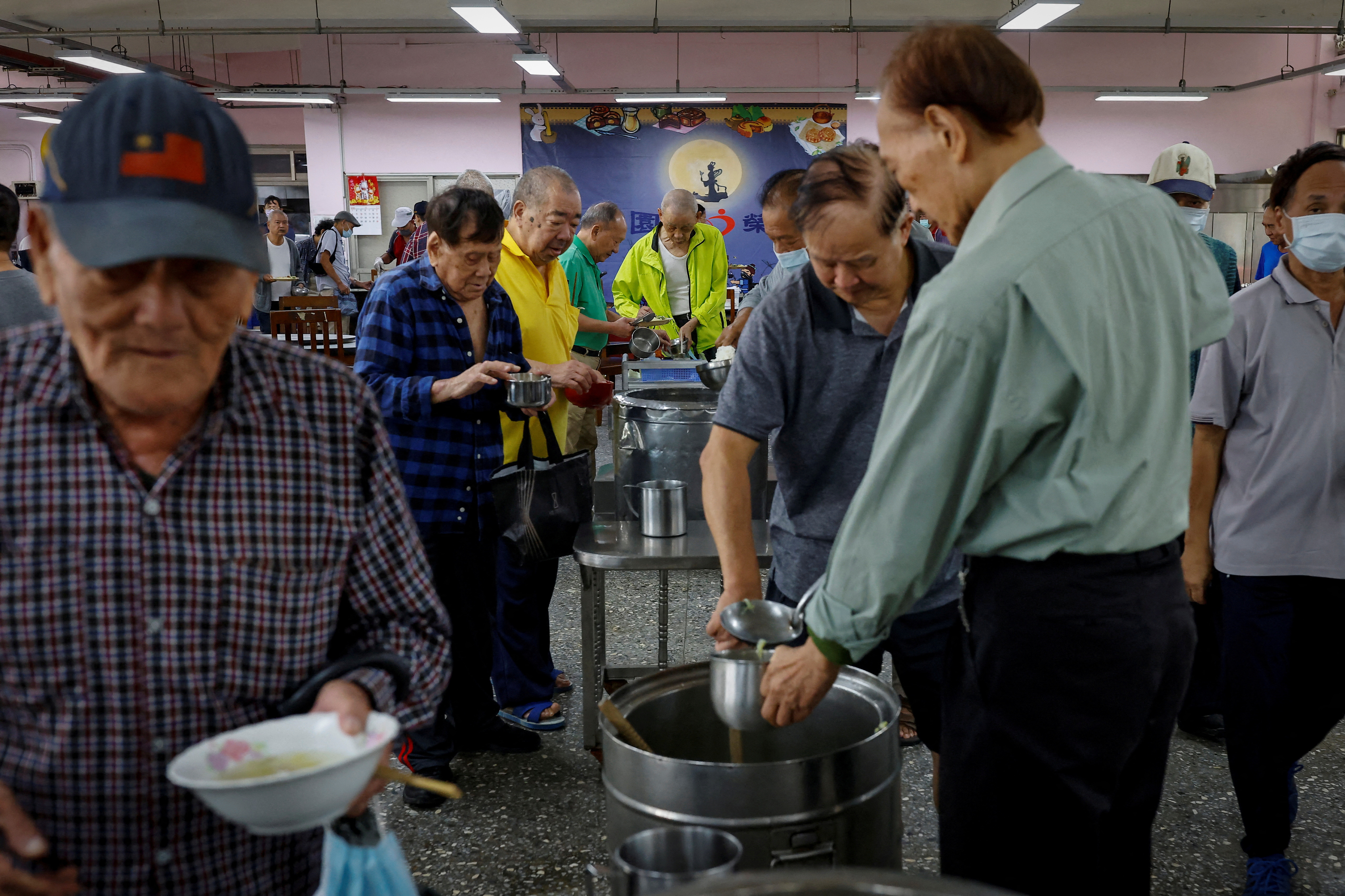 Residents of Taoyuan Veterans Home collect food at the cafeteria during lunch time in Taoyuan, Taiwan.