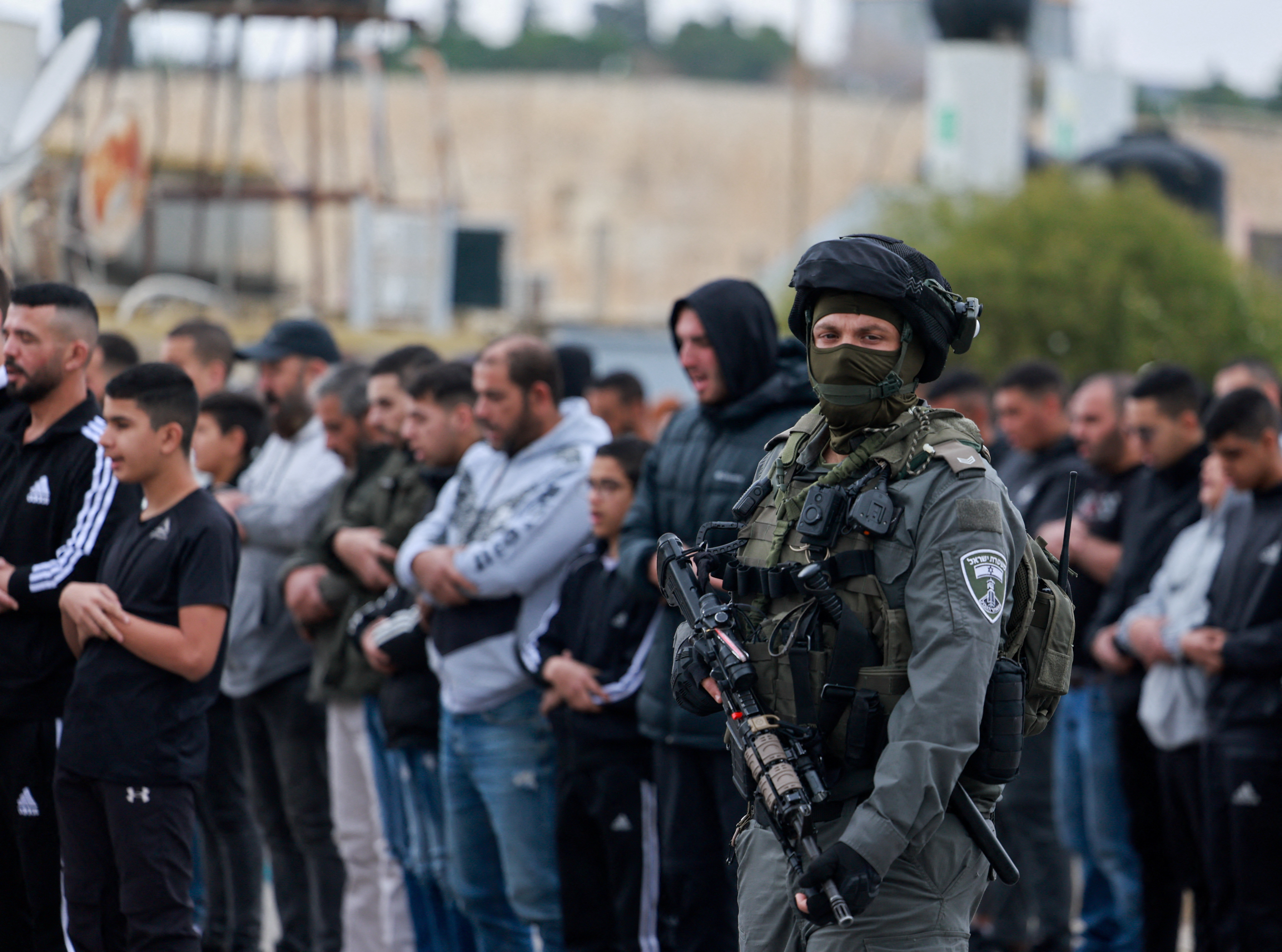 Israeli Border Police officer stands guard, while Palestinian Muslims hold Friday prayers, as the conflict between Israel and the Palestinian Islamist group Hamas continues, in Jerusalem, December 29