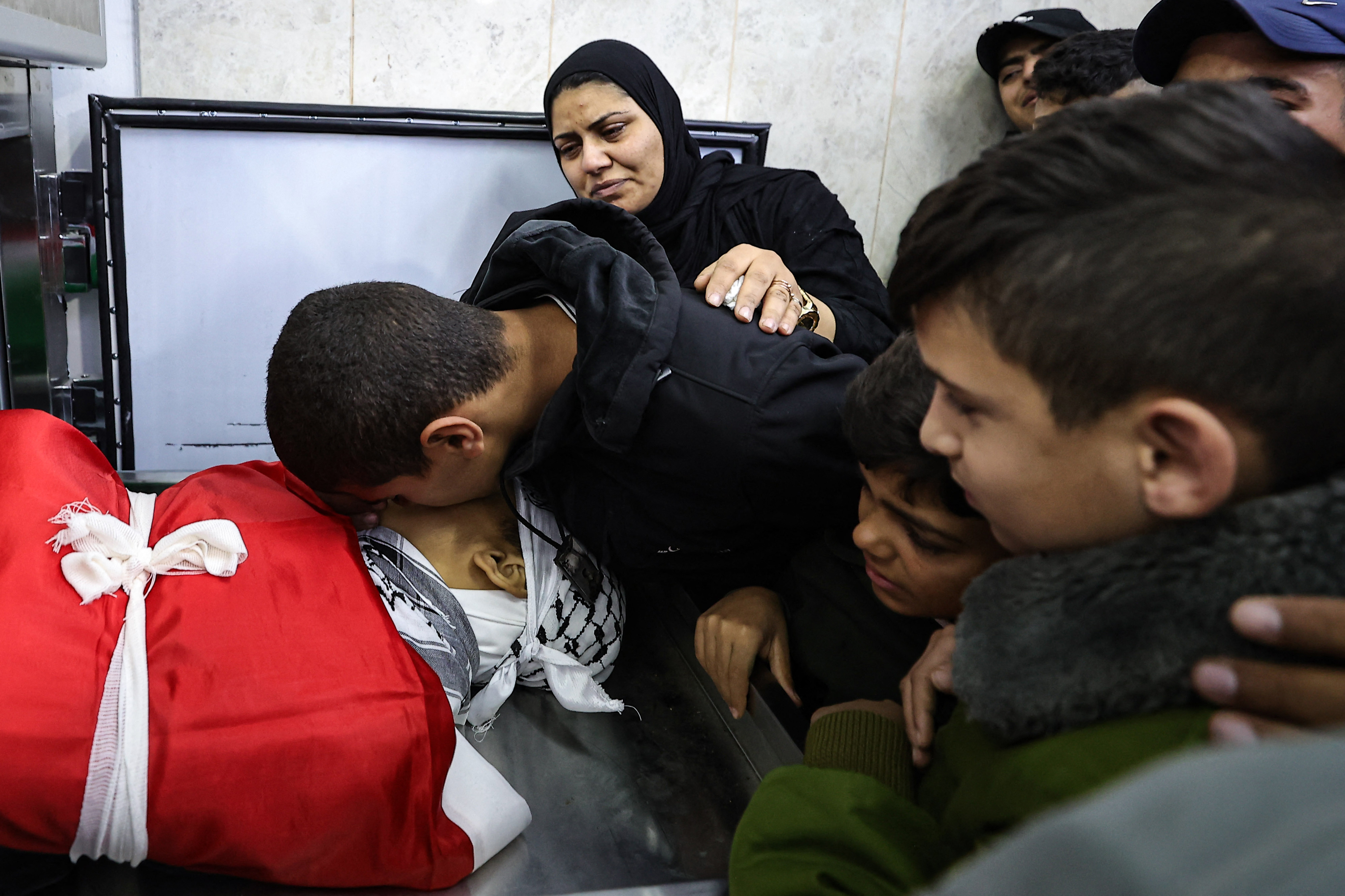 Relatives mourn over the body of one of five people killed in the occupied West Bank city of Jenin during an overnight Israeli incursion, at the morgue of a hospital on November 26.