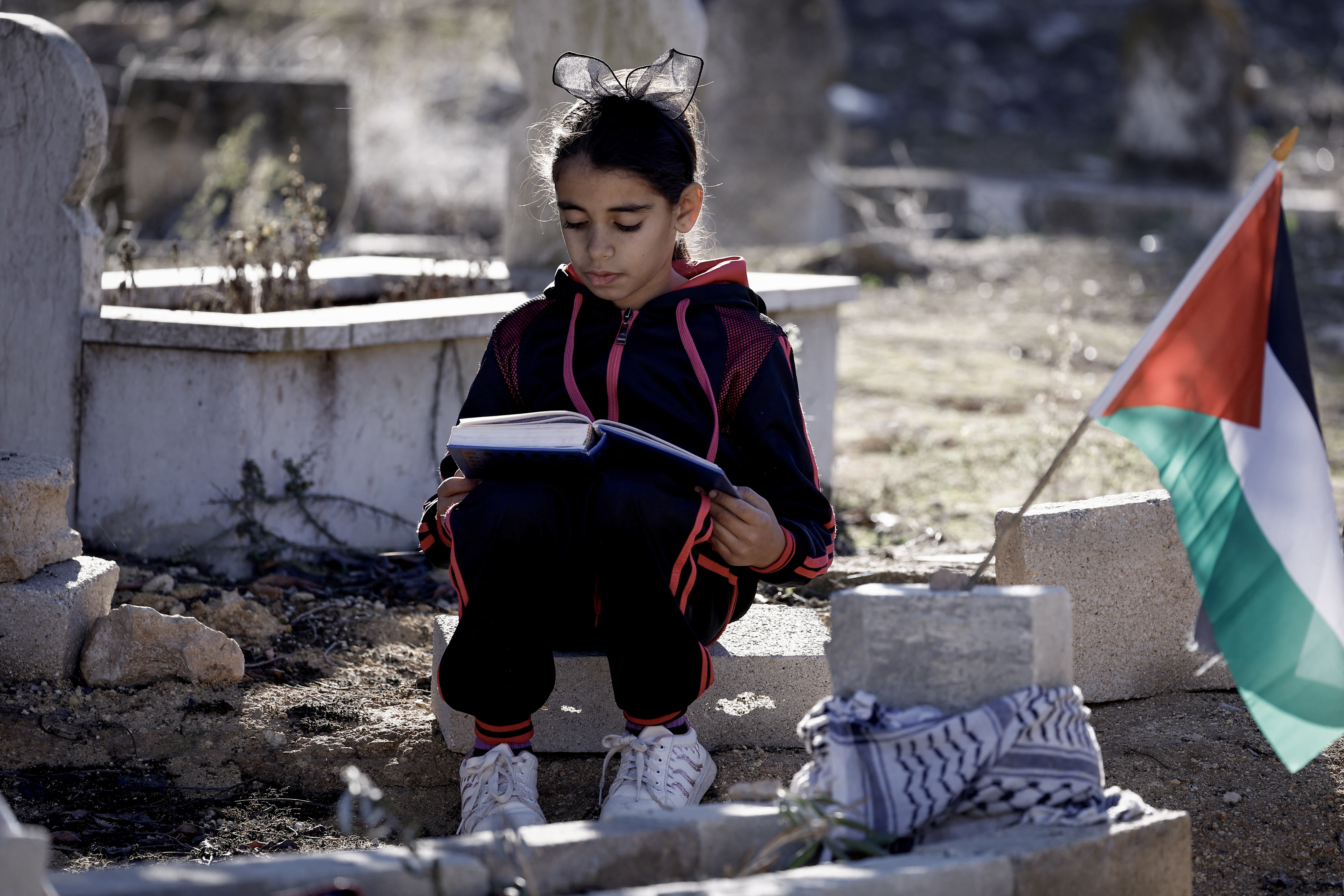 The daughter of Palestinian Bilal Saleh prays near the grave of her late father, at a cemetary in the village of As-Sawiyah, south of Nablus in the occupied West Bank.