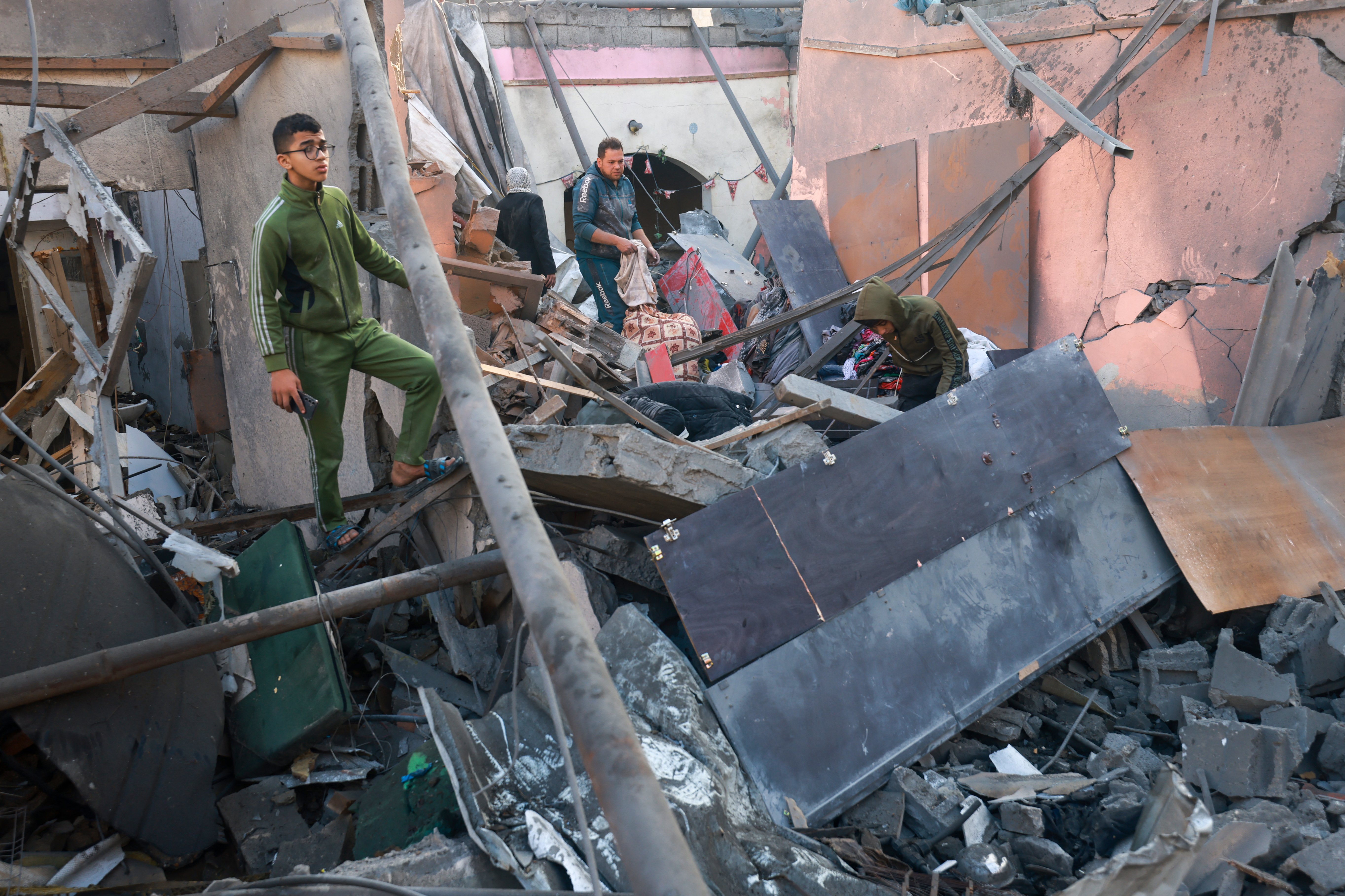 Palestinians look for salvageable items in the rubble of a building destroyed during Israeli bombardment in Rafah, on the southern Gaza Strip.