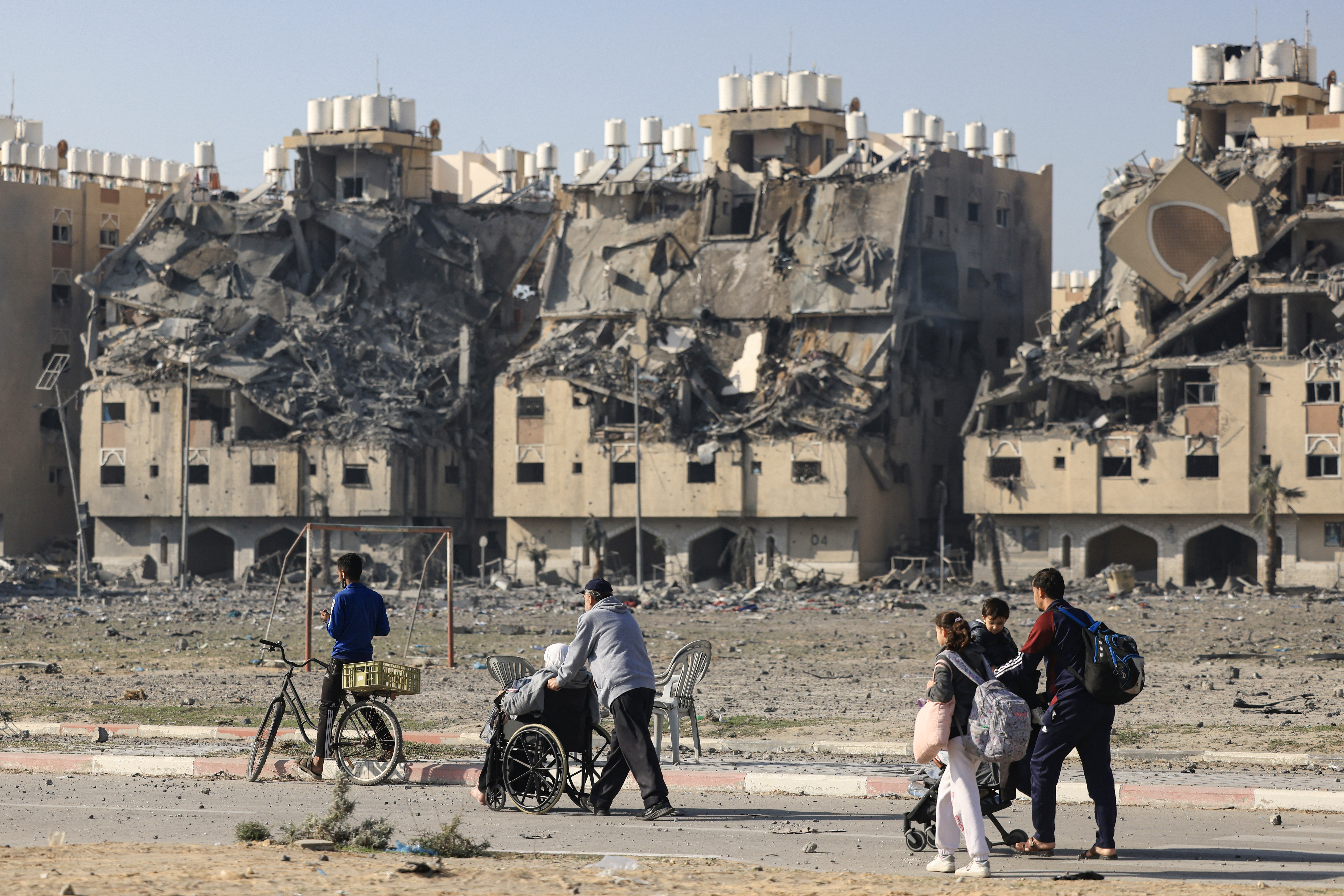 Residents of the Qatari-funded Hamad Town residential complex in Khan Yunis in the southern Gaza Strip, carry some of their belongings as they flee their homes after an Israeli strike.