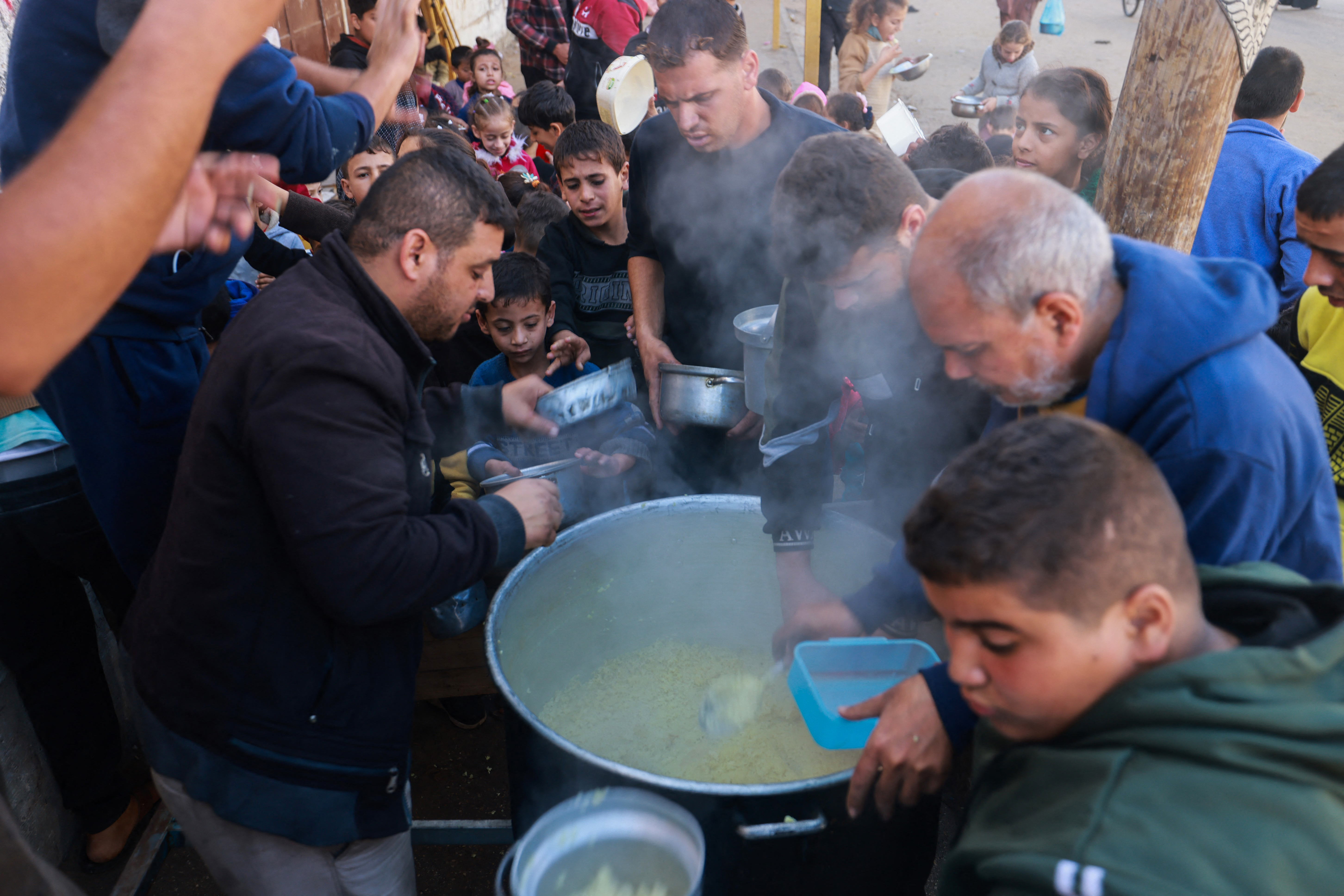 Palestinians collect food at a donation point provided by a charity group in the southern Gaza Strip city of Rafah.