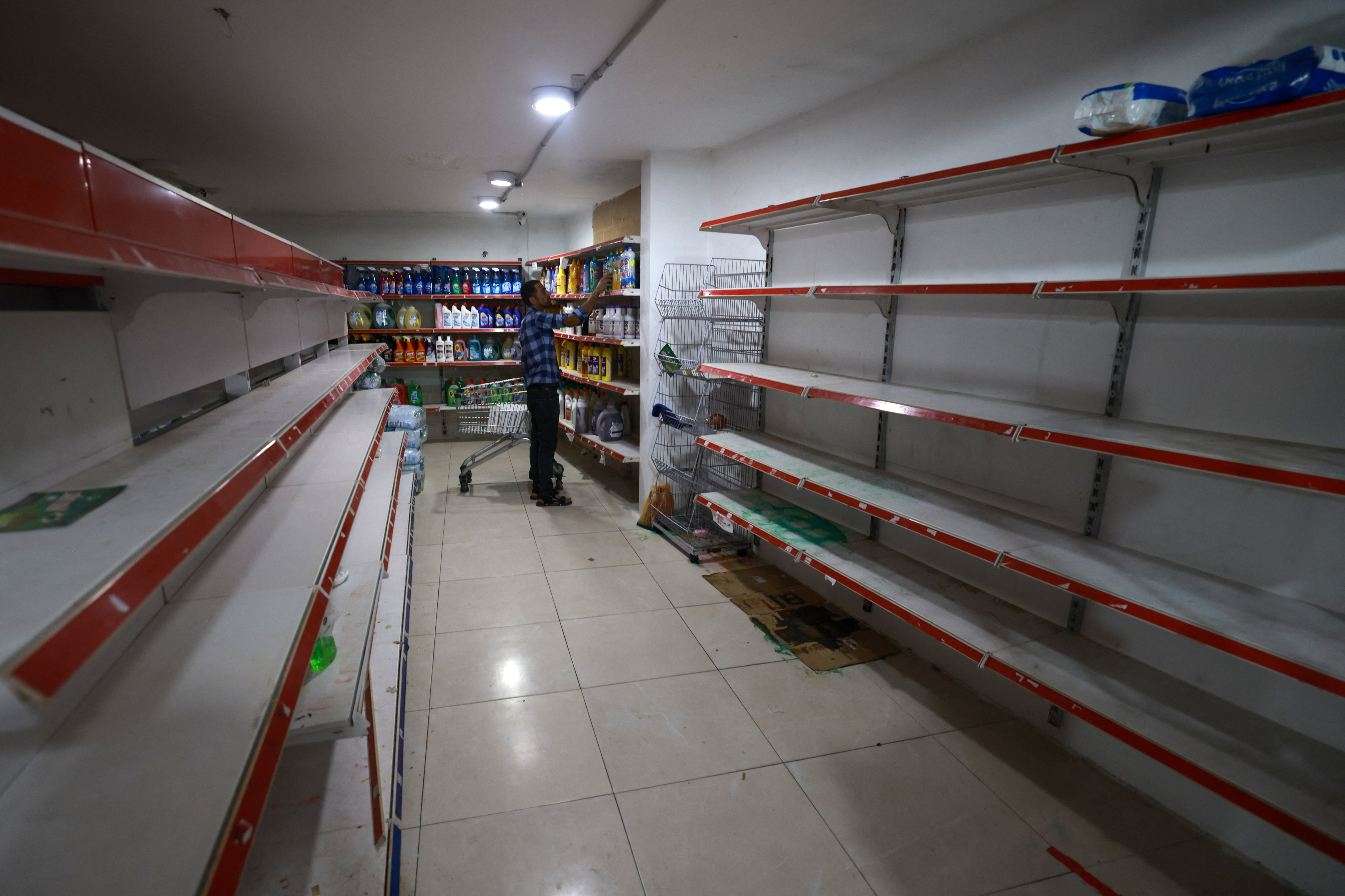 The shelves of a supermarket remain empty apart from cleaning products, in Rafah in the southern Gaza Strip on December 9