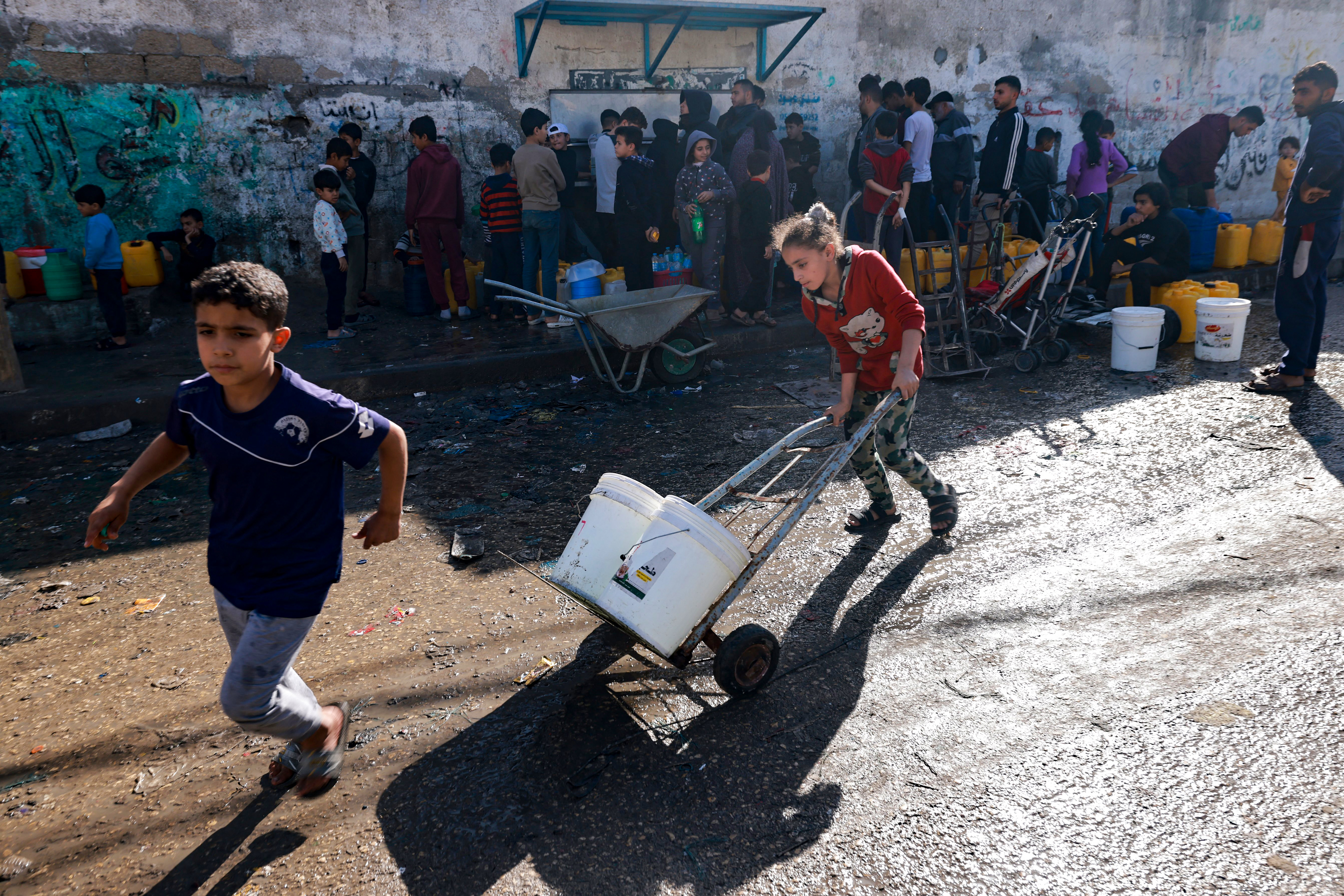 Palestinians fill water canisters in Rafah on the southern Gaza Strip.