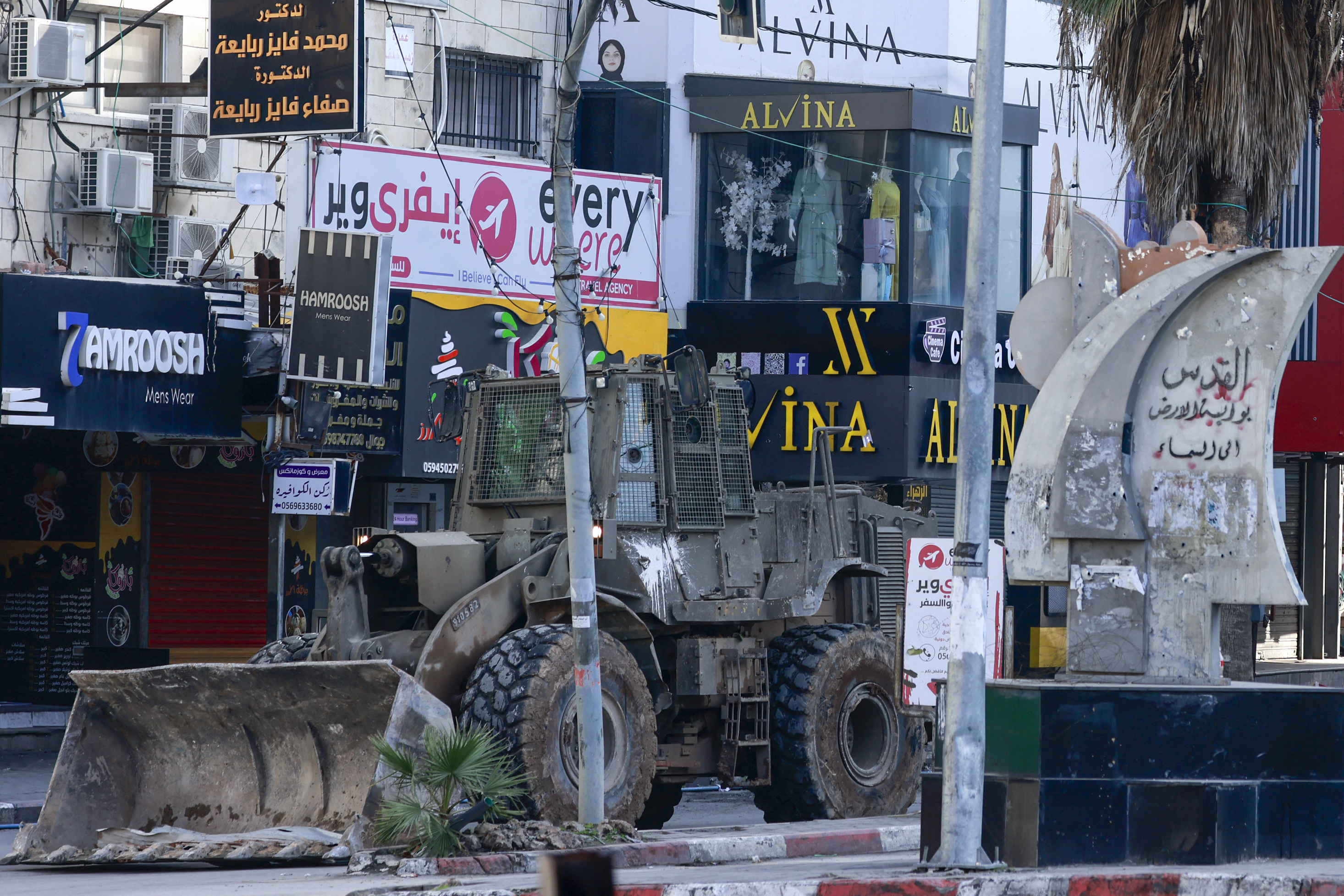 An Israeli military bulldozer drives on a road during a raid in Jenin