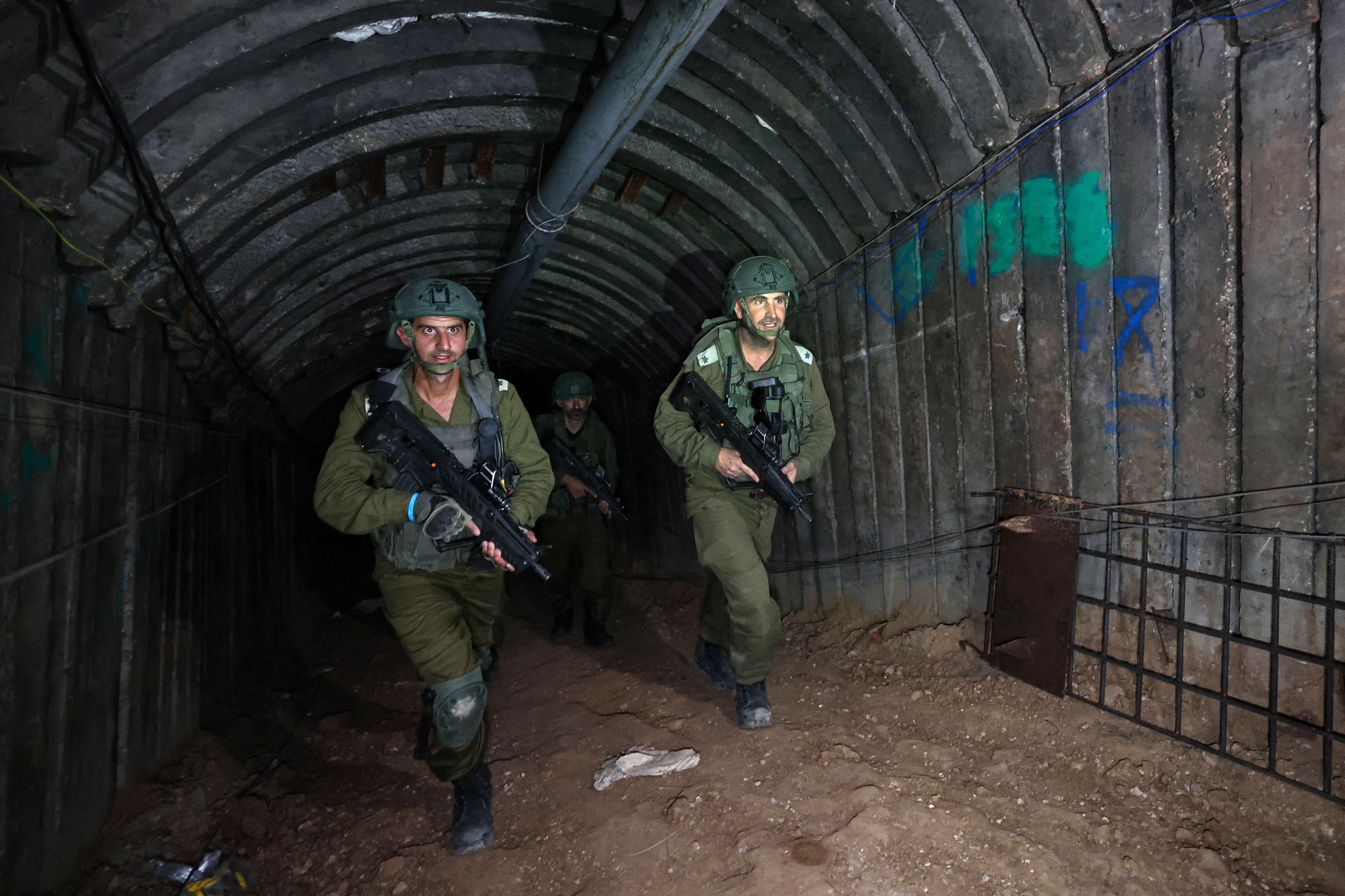 In this picture taken during a media tour organised by the Israeli military on December 15, 2023, soldiers visit a tunnel that Hamas reportedly used to attack Israel through the Erez border crossing on October 7. - The Israeli army said on December 17, 2023 it had uncovered the biggest Hamas tunnel in the Gaza Strip so far, just a few hundred metres from the Erez border crossing. (Photo by JACK GUEZ / AFP)