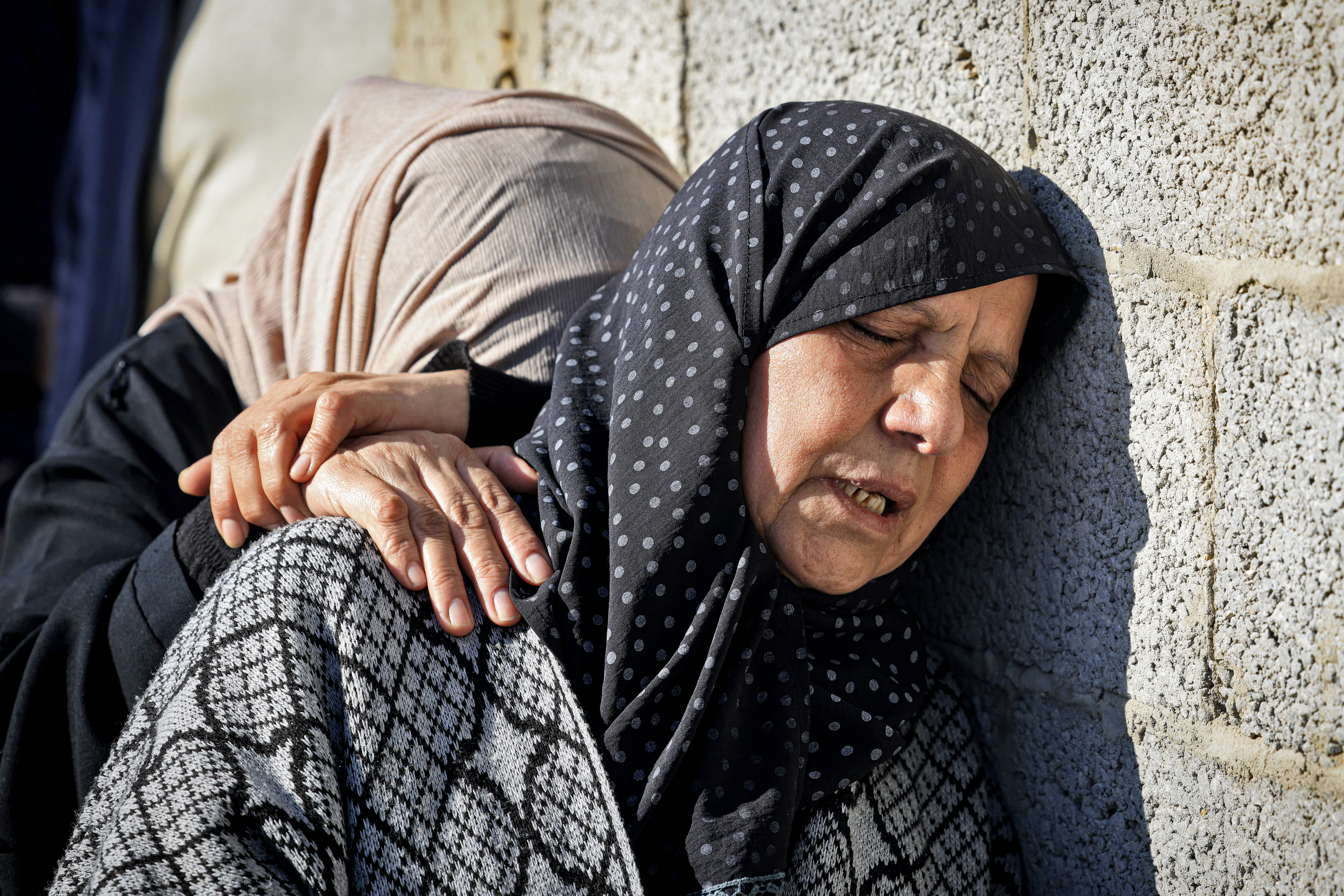 Relatives mourn during the funeral of Al Jazeera cameraman Samer Abu Daqa, who was killed during Israeli bombardment, in Khan Yunis on the southern Gaza Strip on December 16, 2023, amid the continuing battles between Israel and the militant group Hamas. - An Israeli attack killed an Al Jazeera journalist and wounded his colleague in the Gaza Strip on December 15