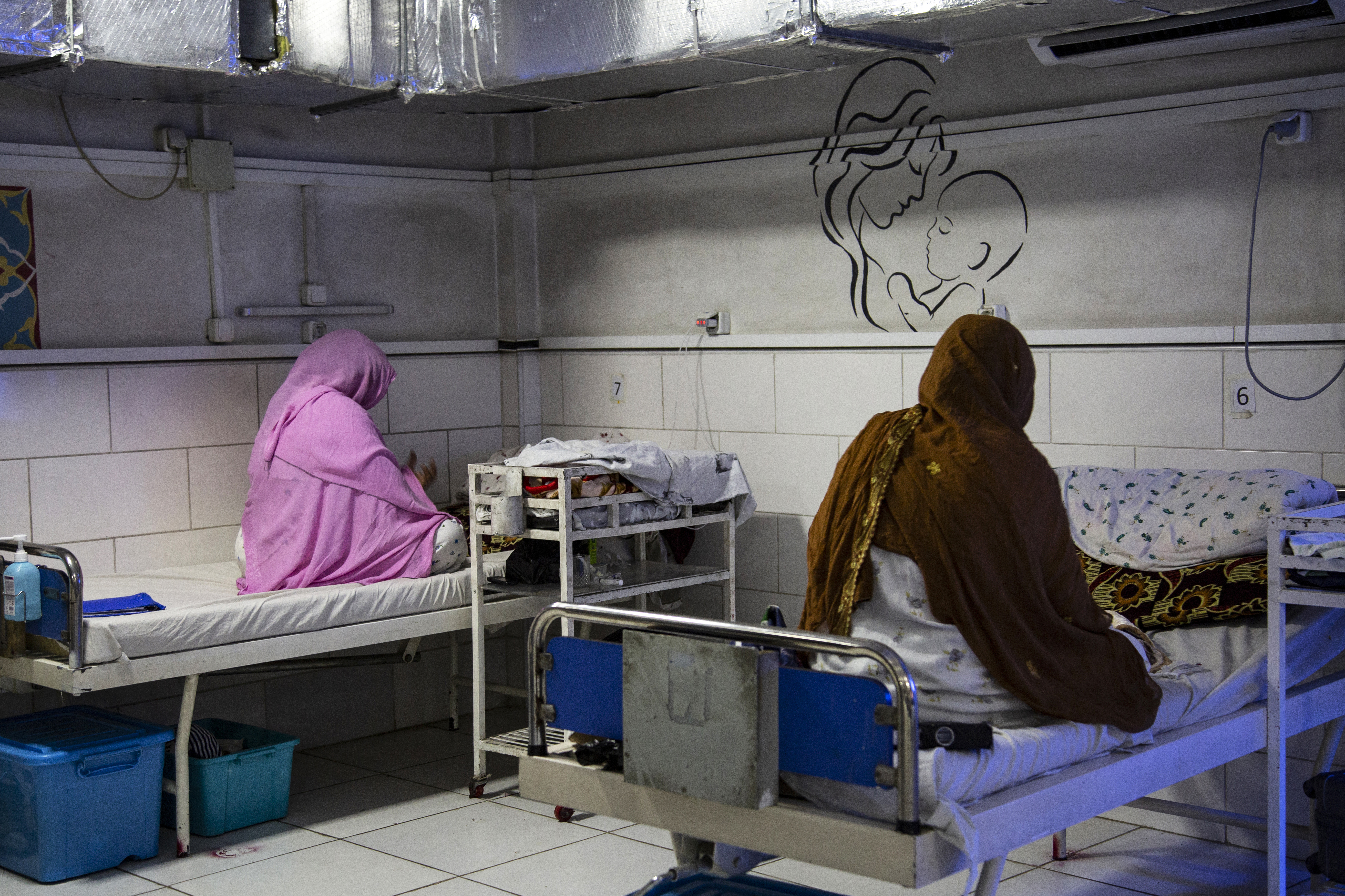 In this photograph taken on December 8, 2023, Afghan women sit beside their newborns at the Doctors Without Borders (MSF)-run maternity hospital in Khost.