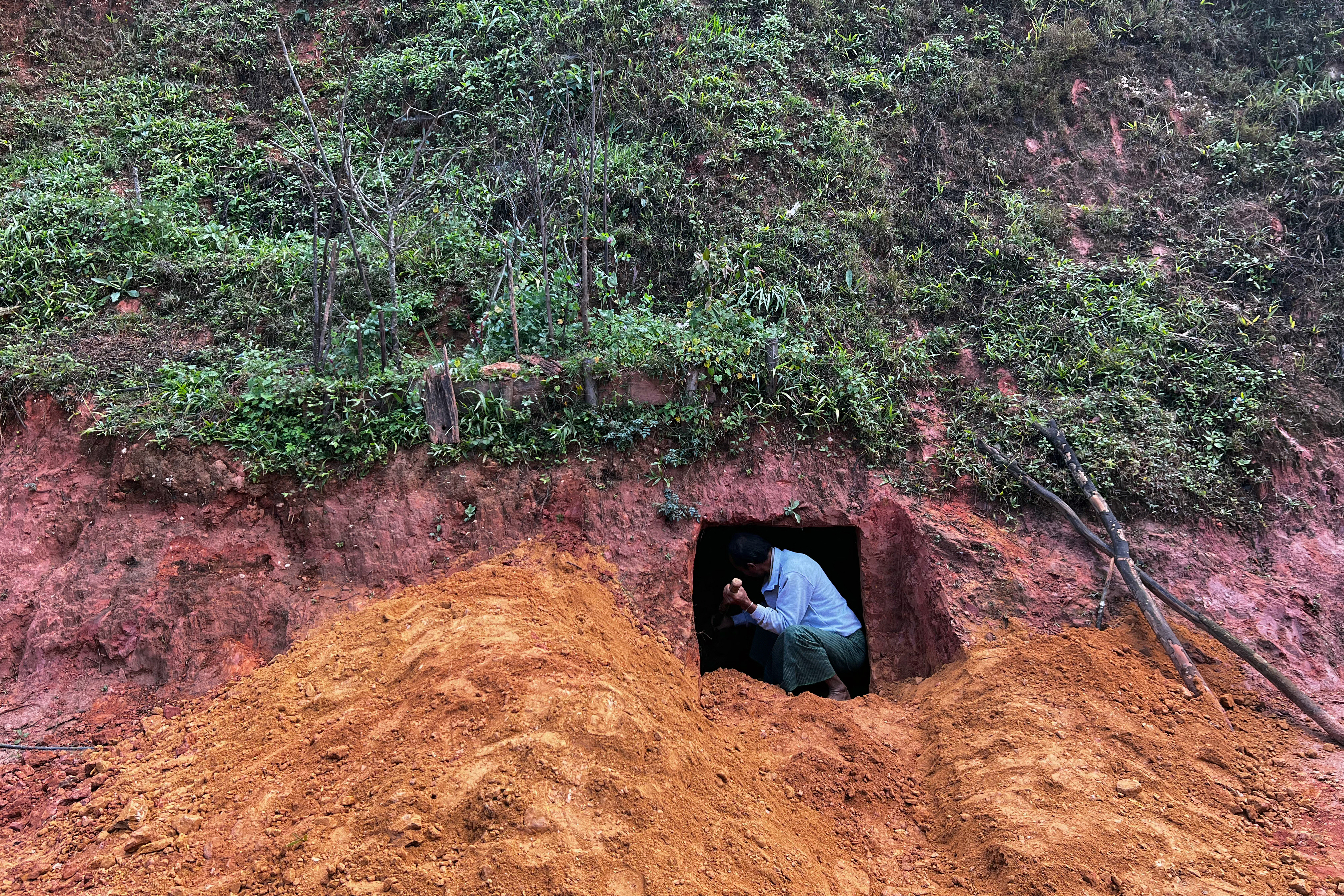 This photo taken on December 14, 2023 shows a man digging a bomb shelter near his house amid clashes between the ethnic minority armed group Ta'ang National Liberation Army (TNLA) and Myanmar's military in Namhsan Township in Myanmar's northern Shan State.