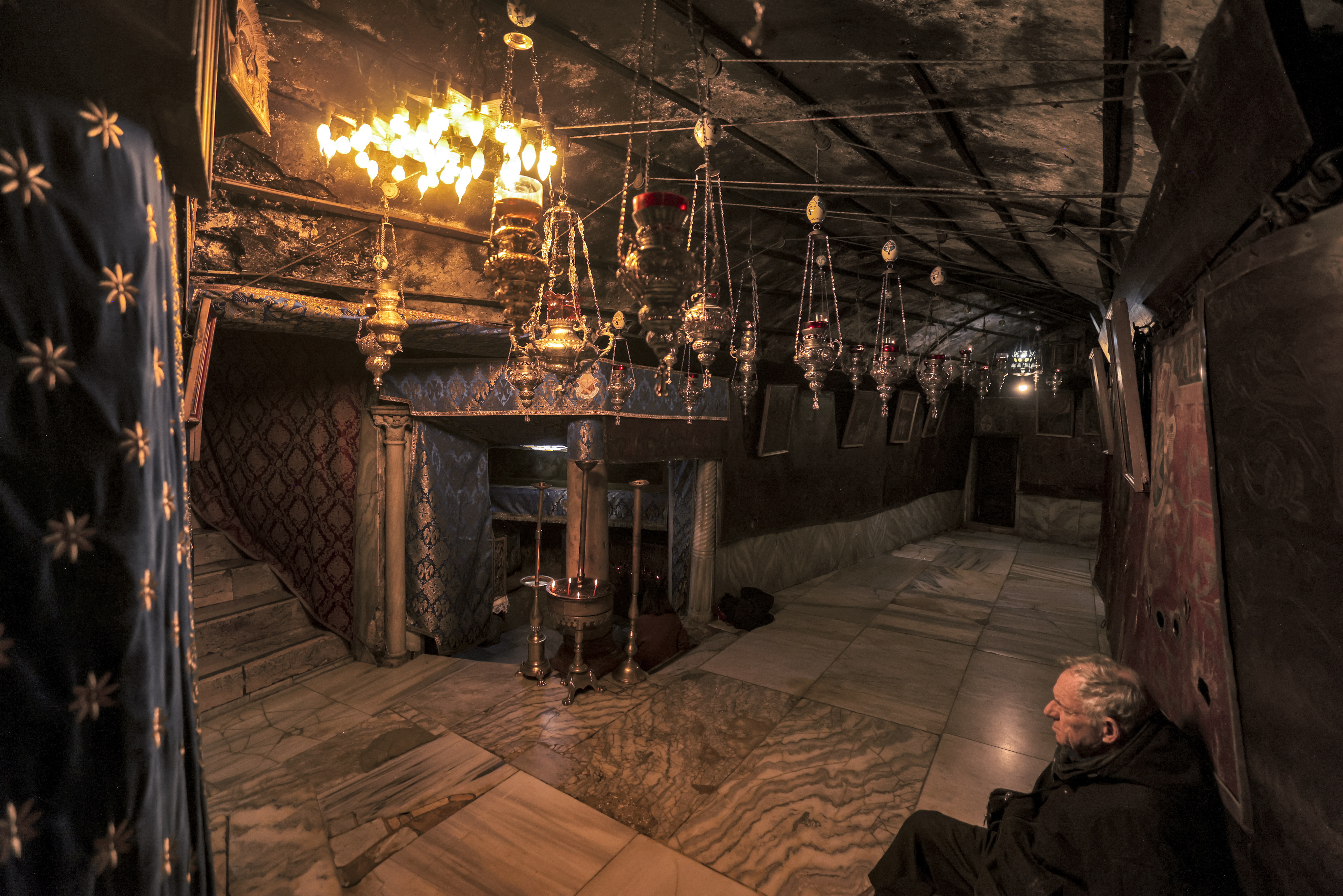A man sits in the deserted Grotto, believed to be the birthplace of Jesus Christ, in the Church of the Nativity in the biblical city of Bethlehem in the occupied West Bank on December 20, 2023 ahead of Christmas amid ongoing battles between Israel and the Palestinian militant group Hamas in the Gaza Strip