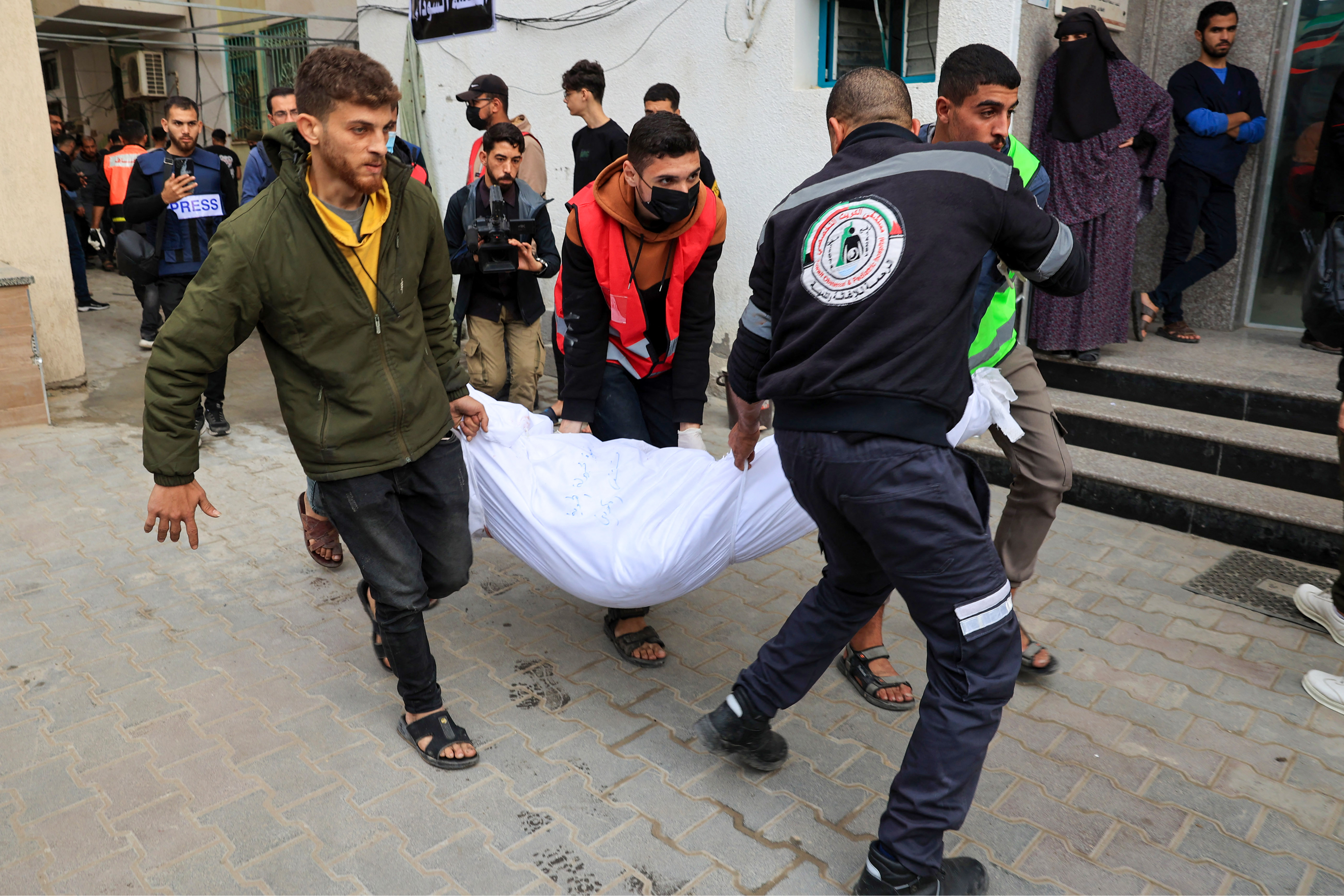 People carry the shrouded body of a person killed during Israeli bombardment at the Kuwait Hospital in Rafah in the southern Gaza Strip.