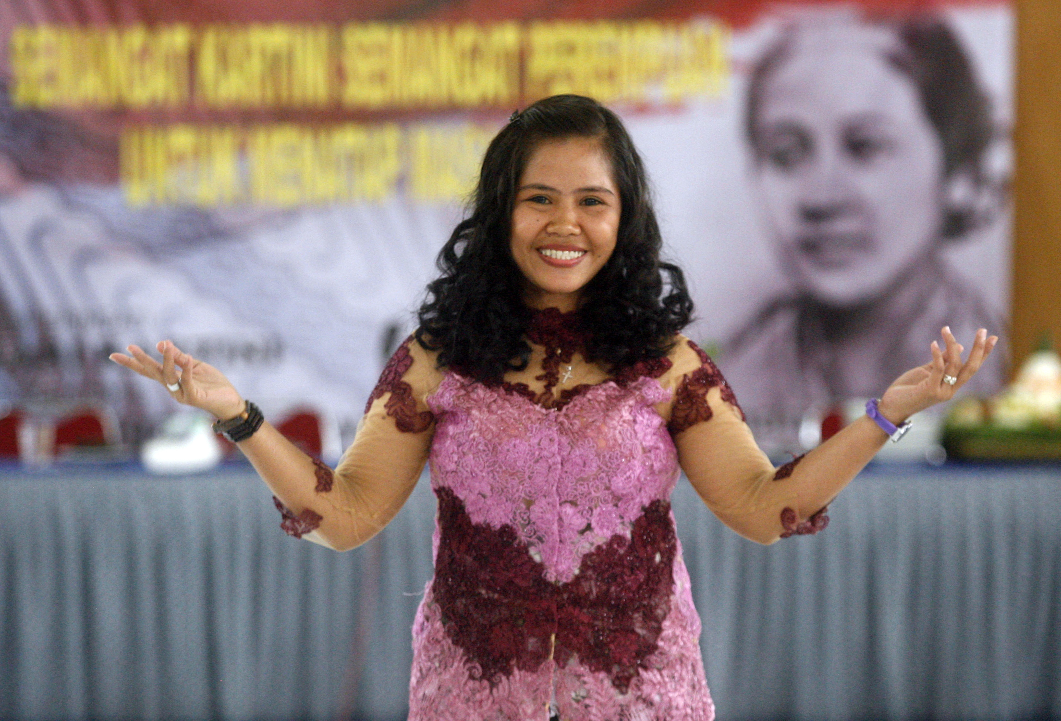 Mary Jane Veloso. She is smiling and wearing a pink and burgundy coloured dress during a fashion show in prison