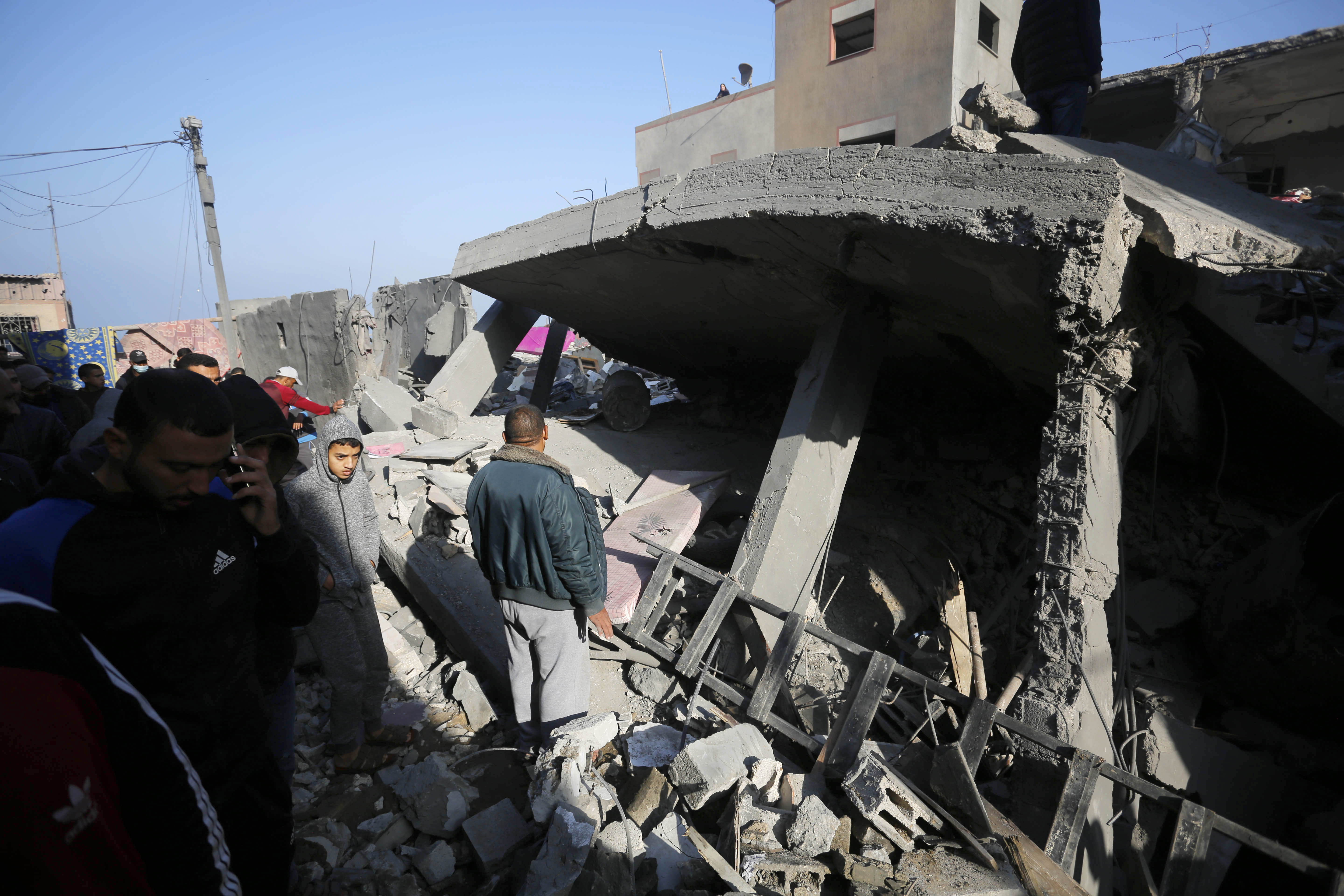 An aerial view of Palestinian search and rescue team and civilians gathering to conduct search and rescue operation among rubble of buildings in Deir Al Balah