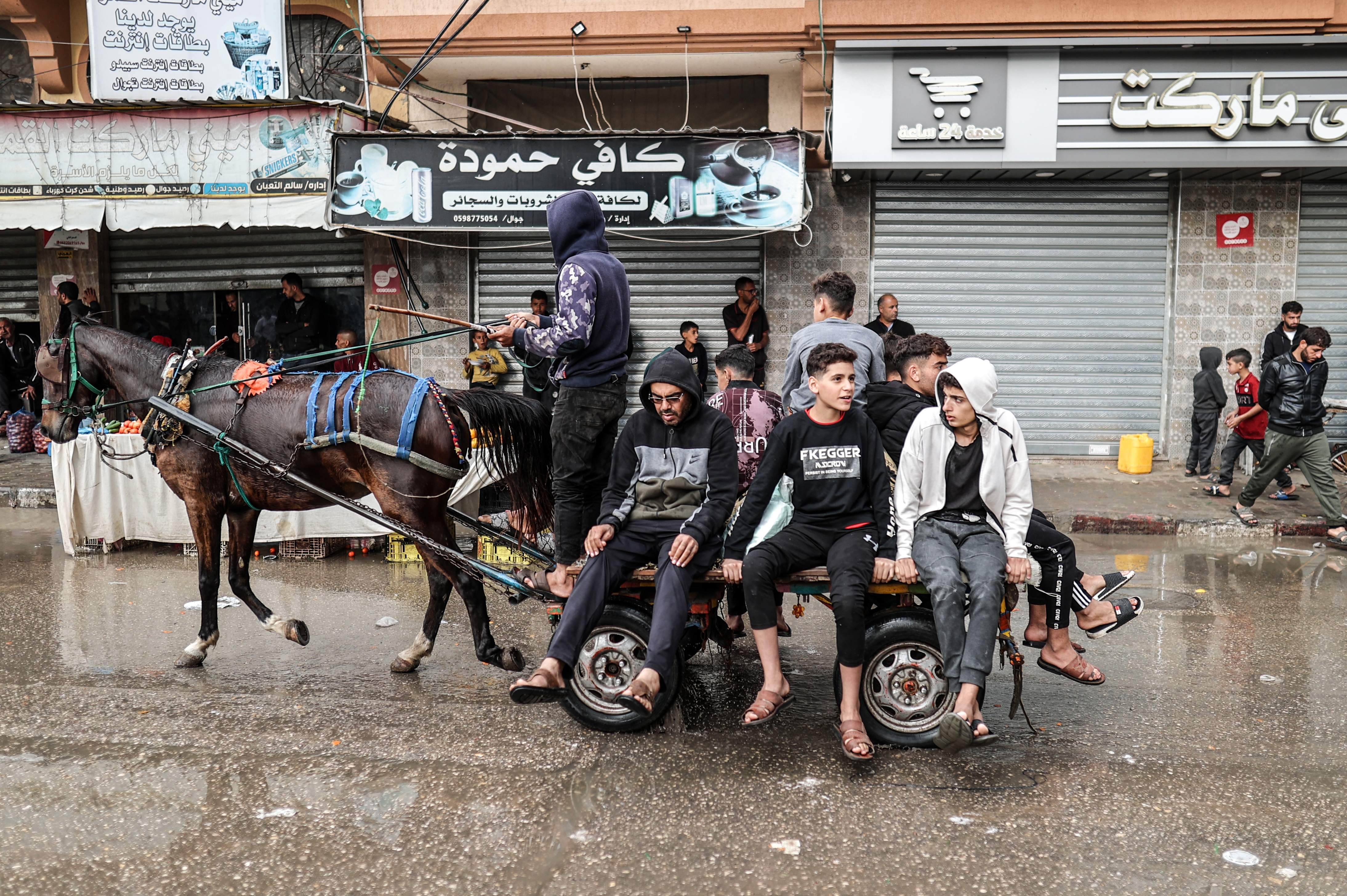 Palestinians move by cart under the rain as Palestinians who took shelter in the Aqsa Martyrs Hospital and its surroundings in Deir Al-Balah city of the Gaza struggle with the strong winds, heavy rain and floods affecting the region amid Israeli attacks.