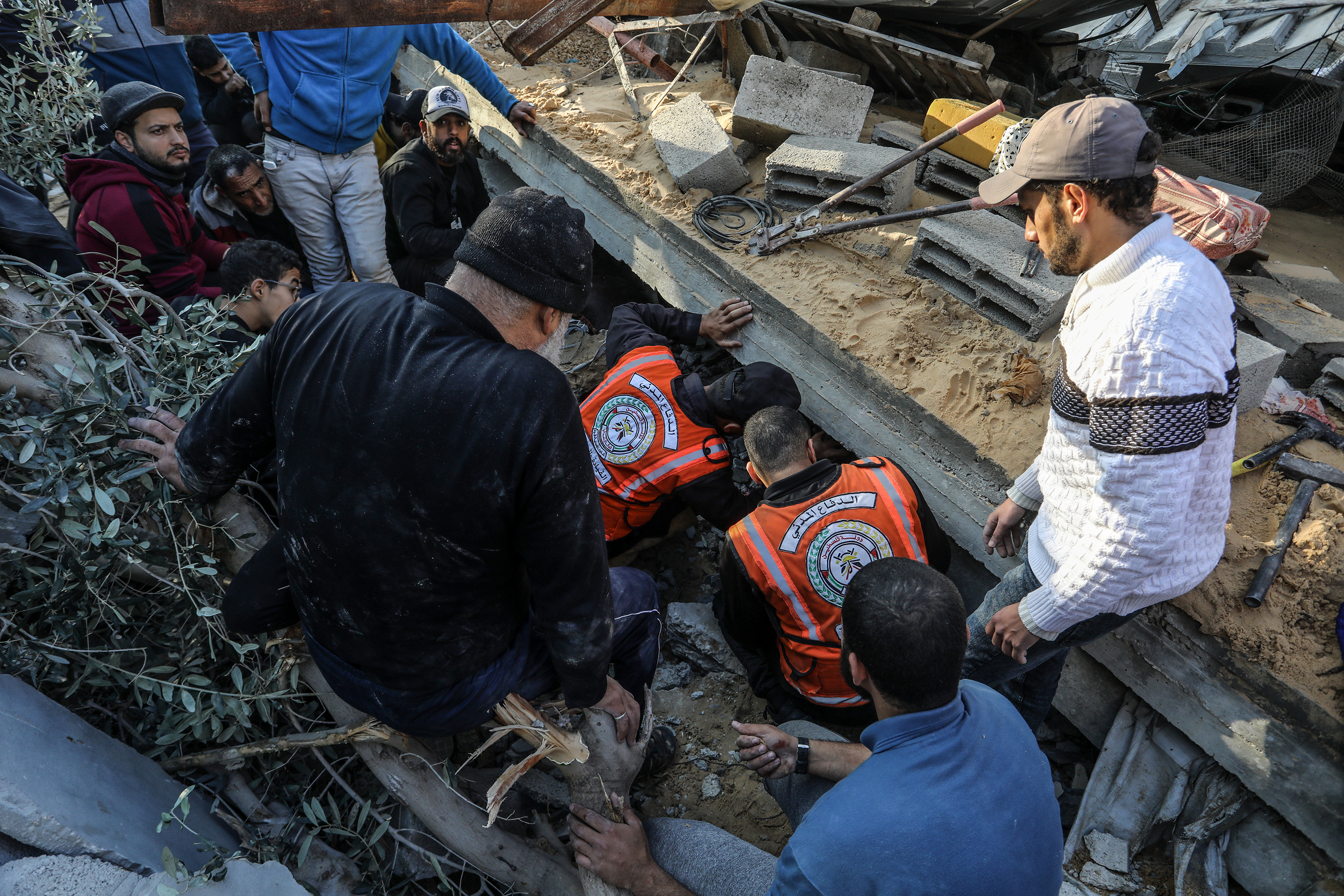 Civil defense teams carry out search and rescue operations under debris of destroyed buildings after Israeli airstrike in Rafah, Gaza.