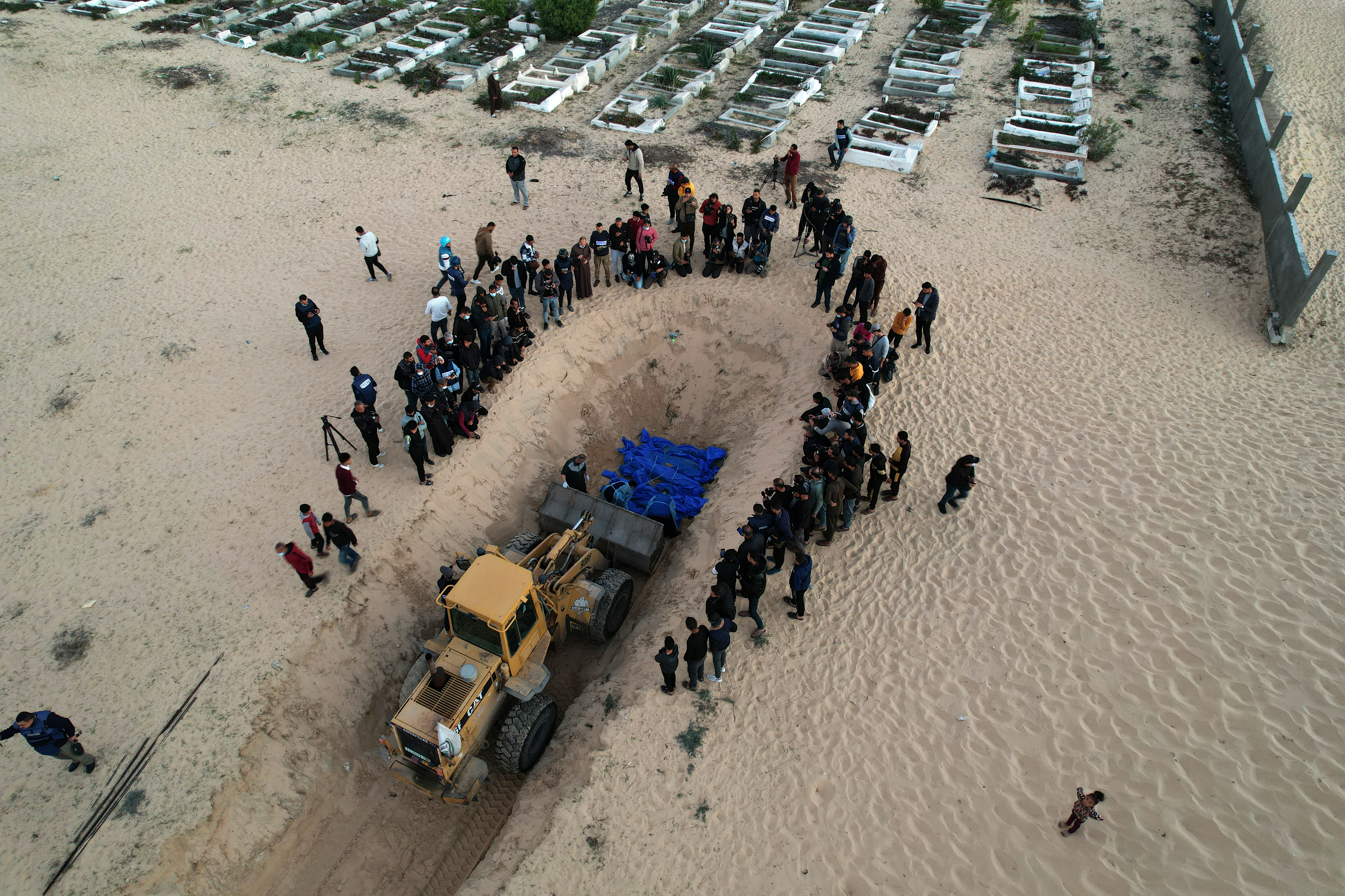An aerial view of burial of the 80 Palestinians who died in Israeli attacks, to a mass grave at Tel al-Sultan Cemetery in Rafah, Gaza on December 26