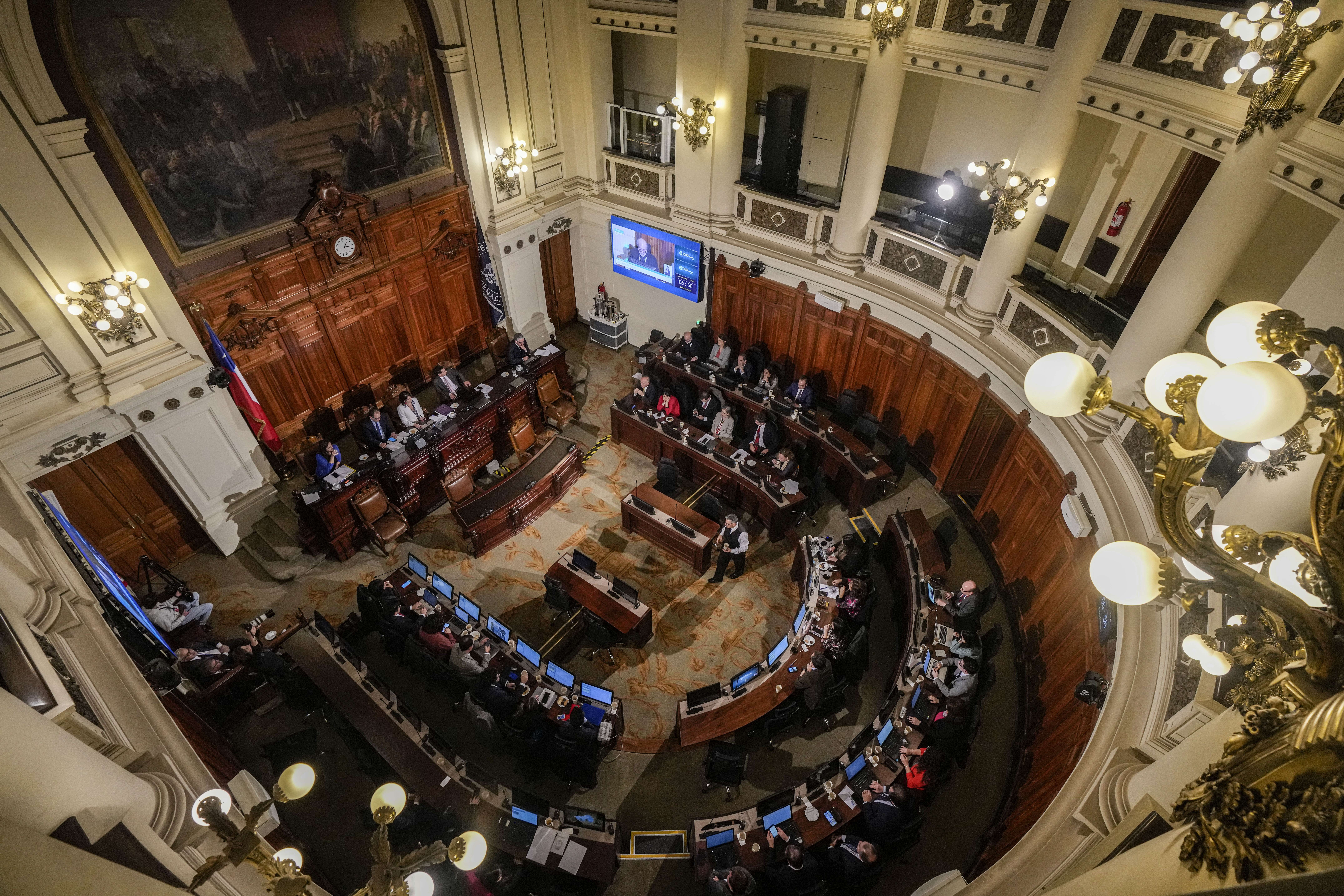 An aerial view looking down on a government chamber where a constitutional council is in session.