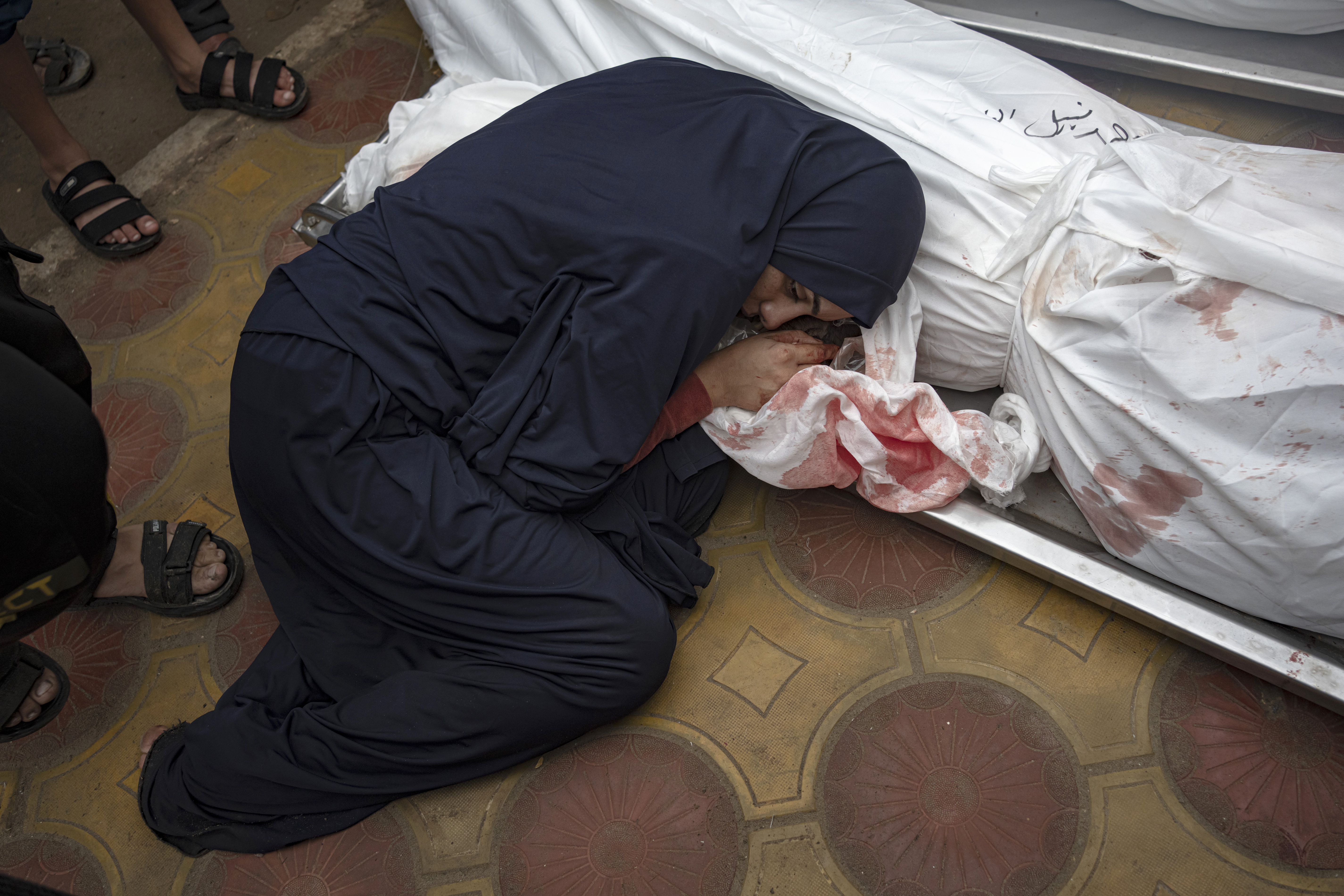 A woman mourns her child and her husband killed in an Israeli army bombardment of the Gaza Strip, in the hospital in Khan Younis, Tuesday Dec. 5