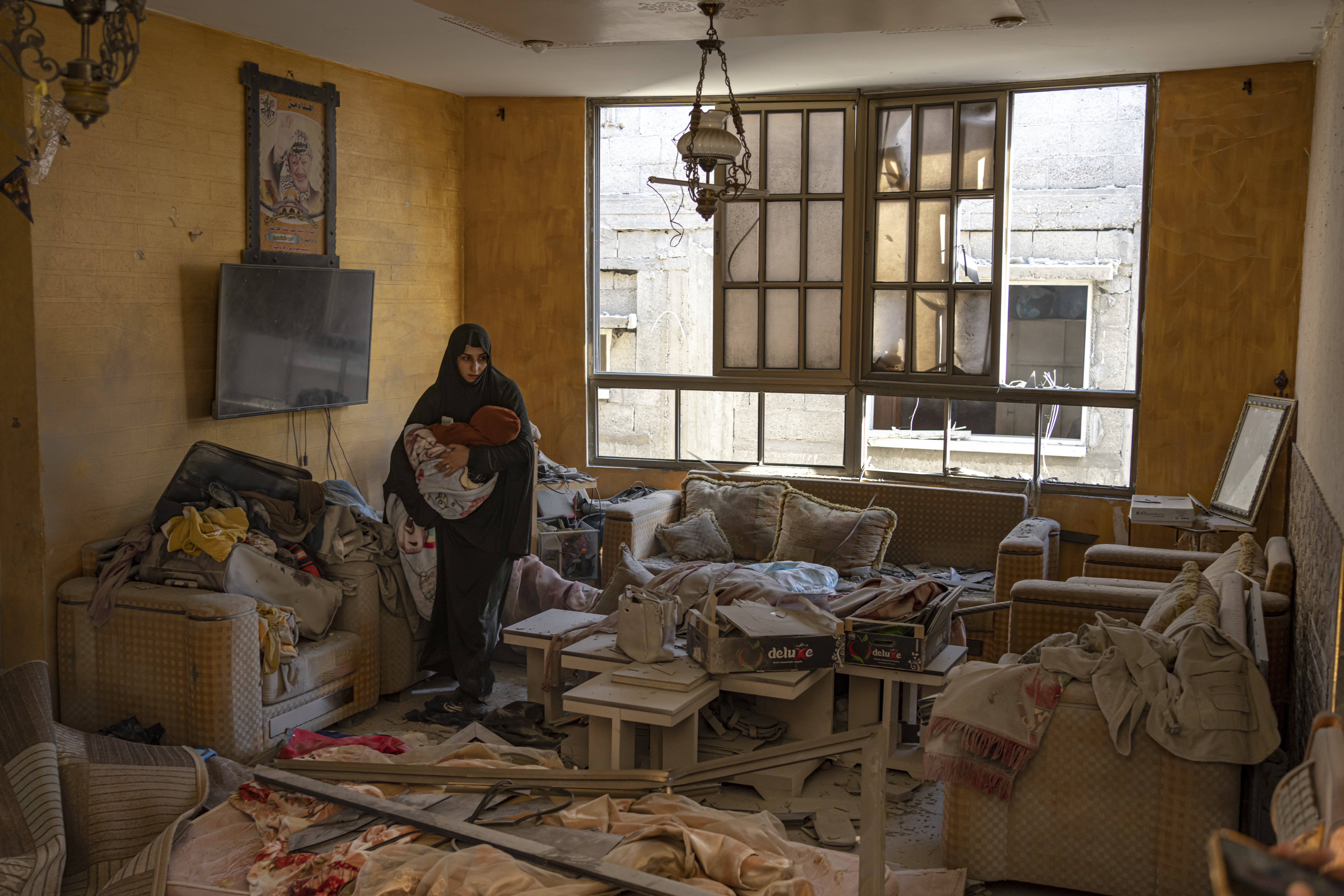 A Palestinian woman holds her child after an Israeli strike on her neighborhood in Rafah