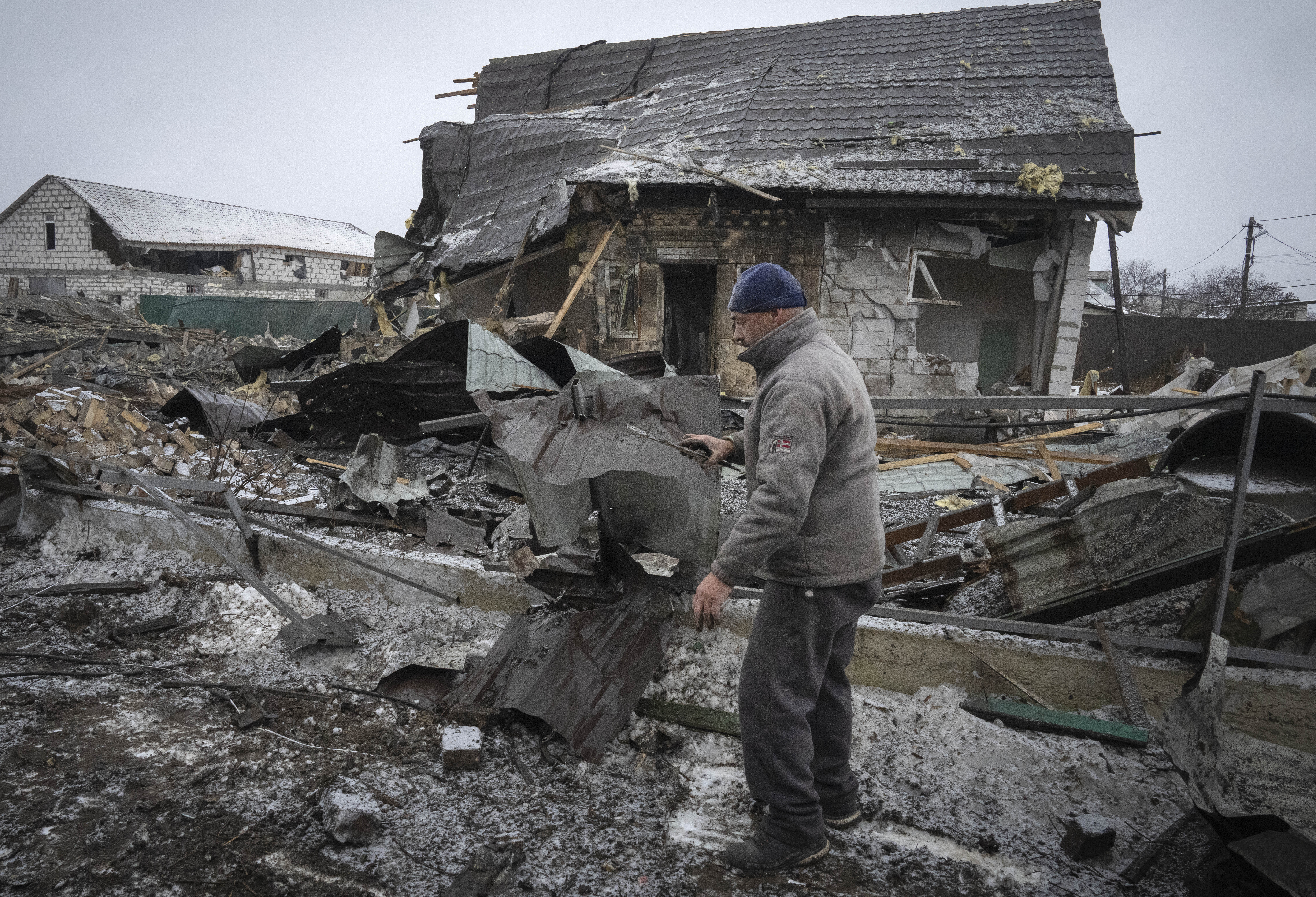 A local resident sorts out debris at the site of a private house ruined in the Russian missile attack in Kyiv, Ukrain