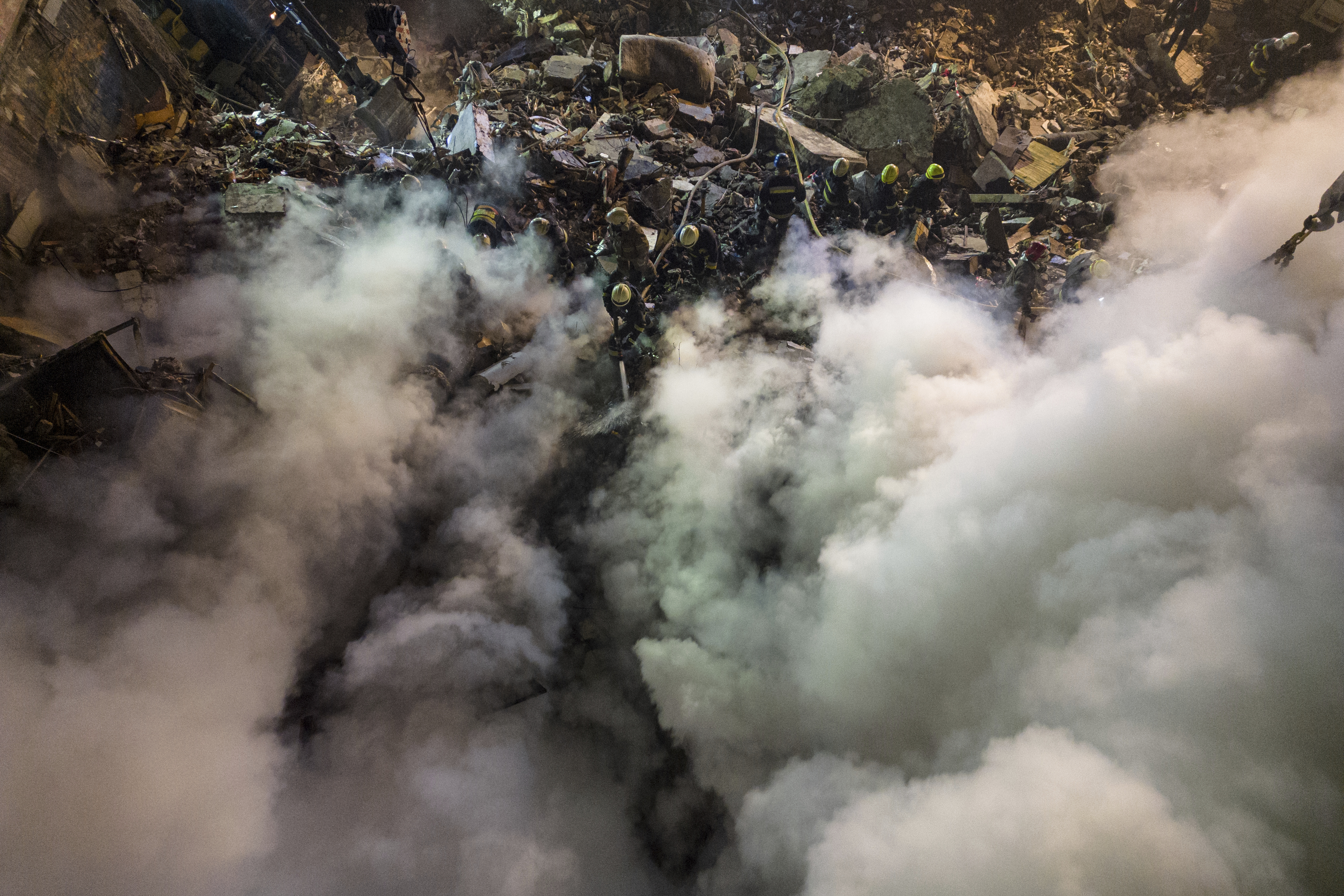 Emergency workers clear the rubble after a Russian rocket hit a multistory building leaving many people under debris in the southeastern city of Dnipro, Ukraine, on Jan. 14