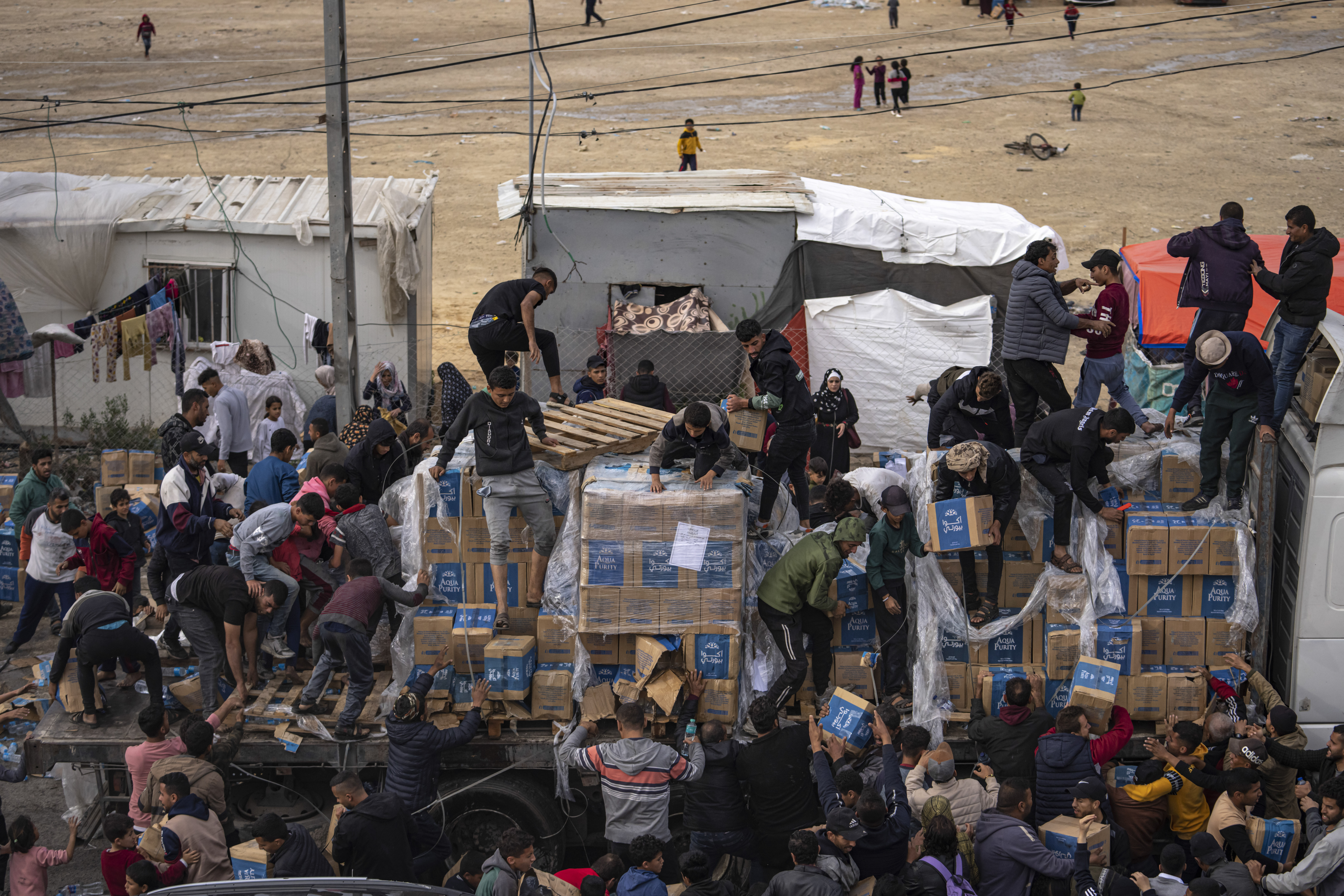 Palestinians loot a humanitarian aid truck as it crossed into the Gaza Strip in Rafah, Sunday