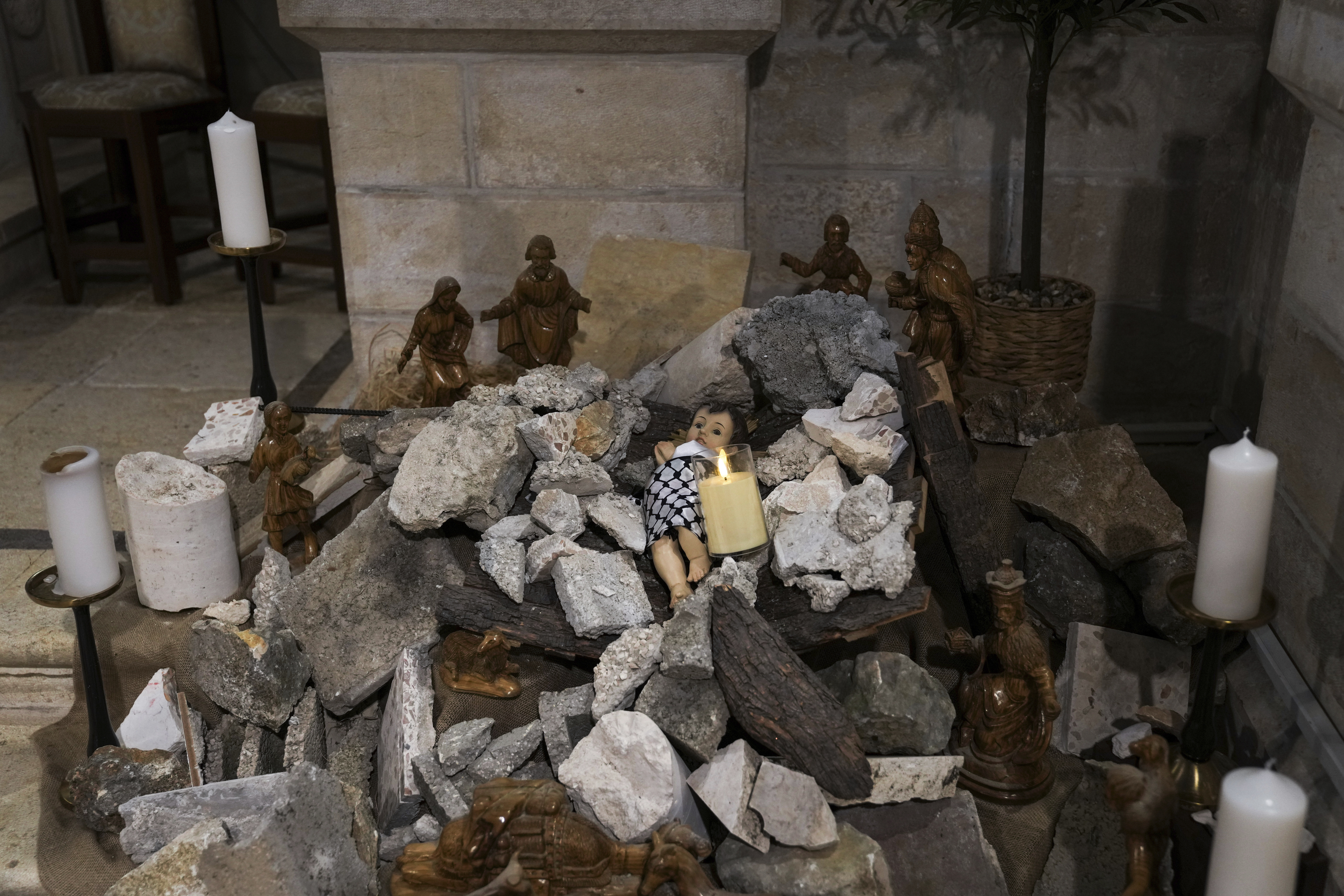 An installation of a scene of the Nativity of Christ with a figure symbolizing baby Jesus lying amid the rubble, in reference to Gaza, inside an Evangelical Lutheran Church in the West Bank town of Bethlehem, Sunday, Dec. 10