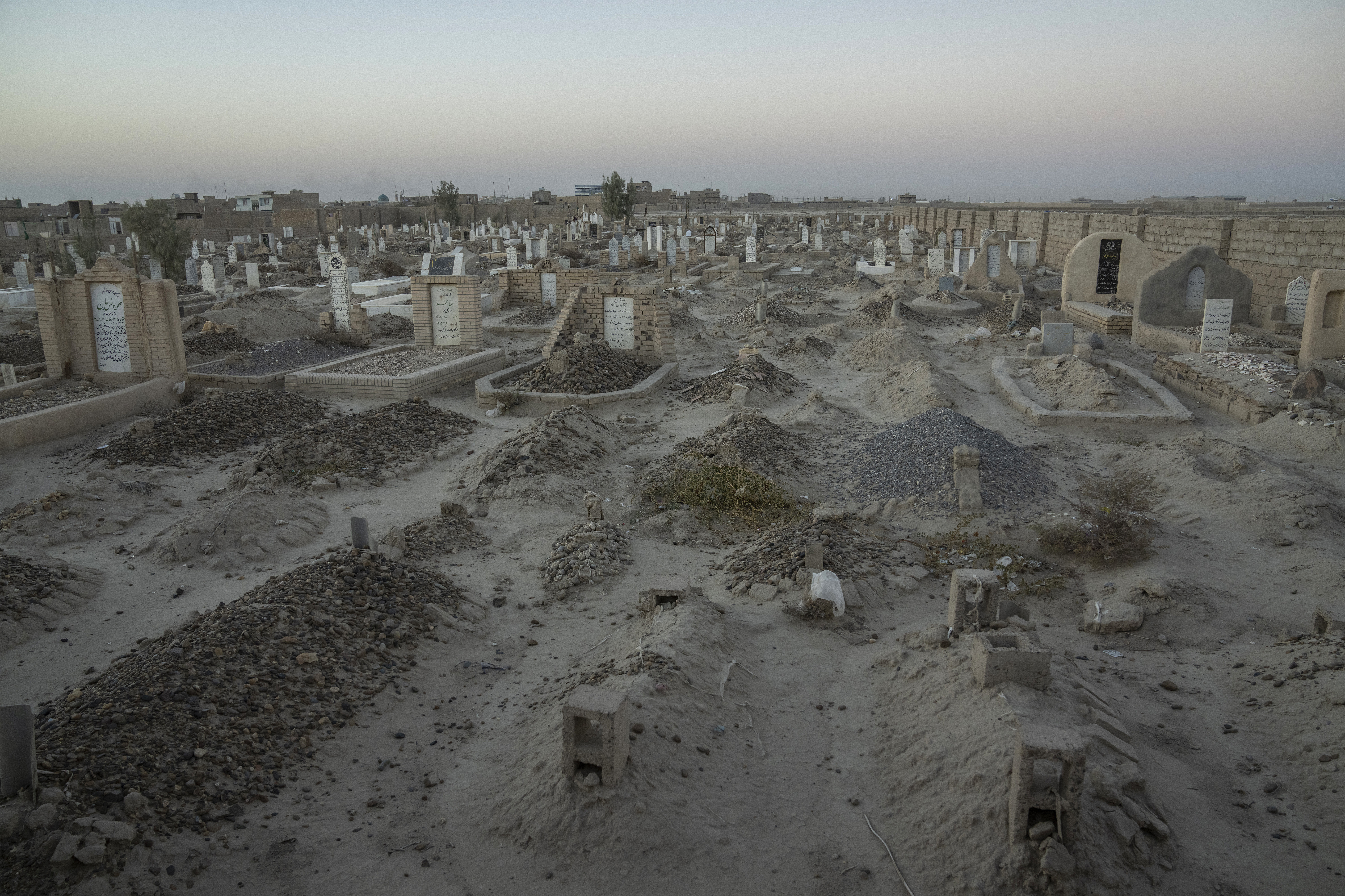 An Afghan Shiite cemetery, where a large number of Shiite migrants who were killed while trying to cross the border are buried, lies on the outskirts of Zaranj city, Afghanistan, Monday, Dec. 25