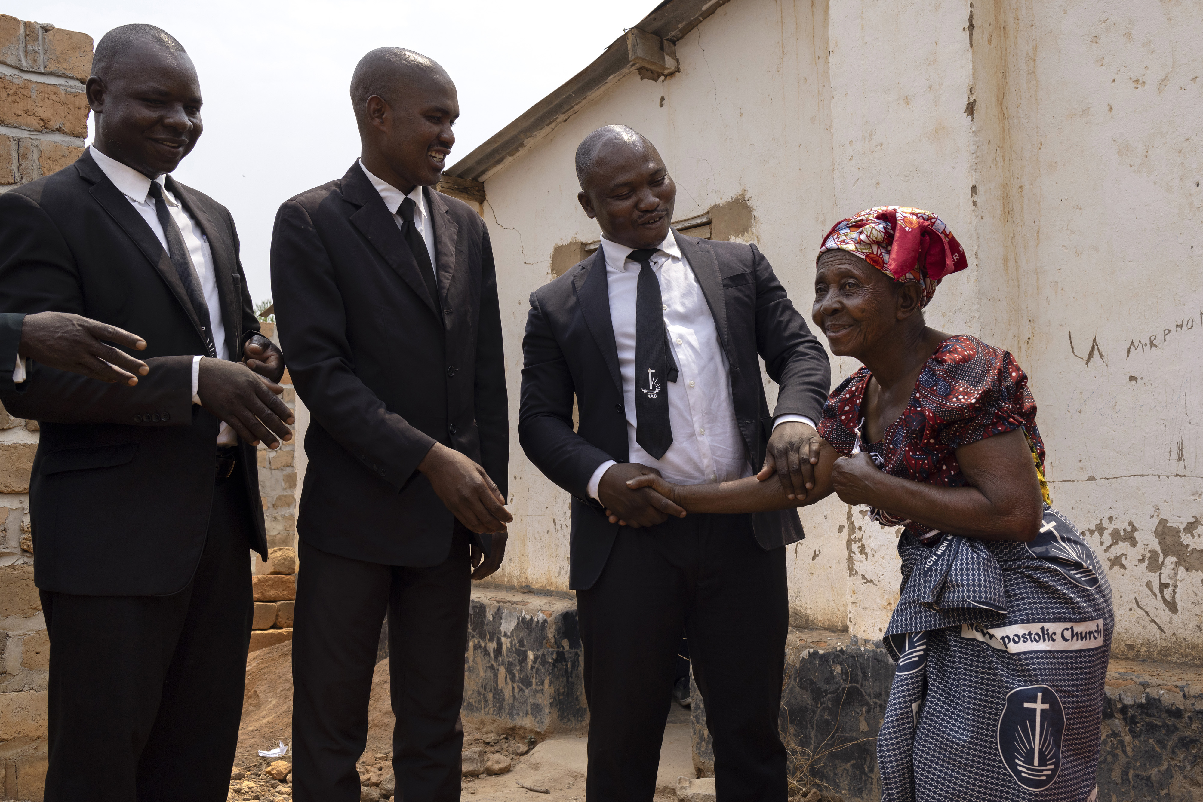 A church priest and his colleagues in a refugee camp in Zambia