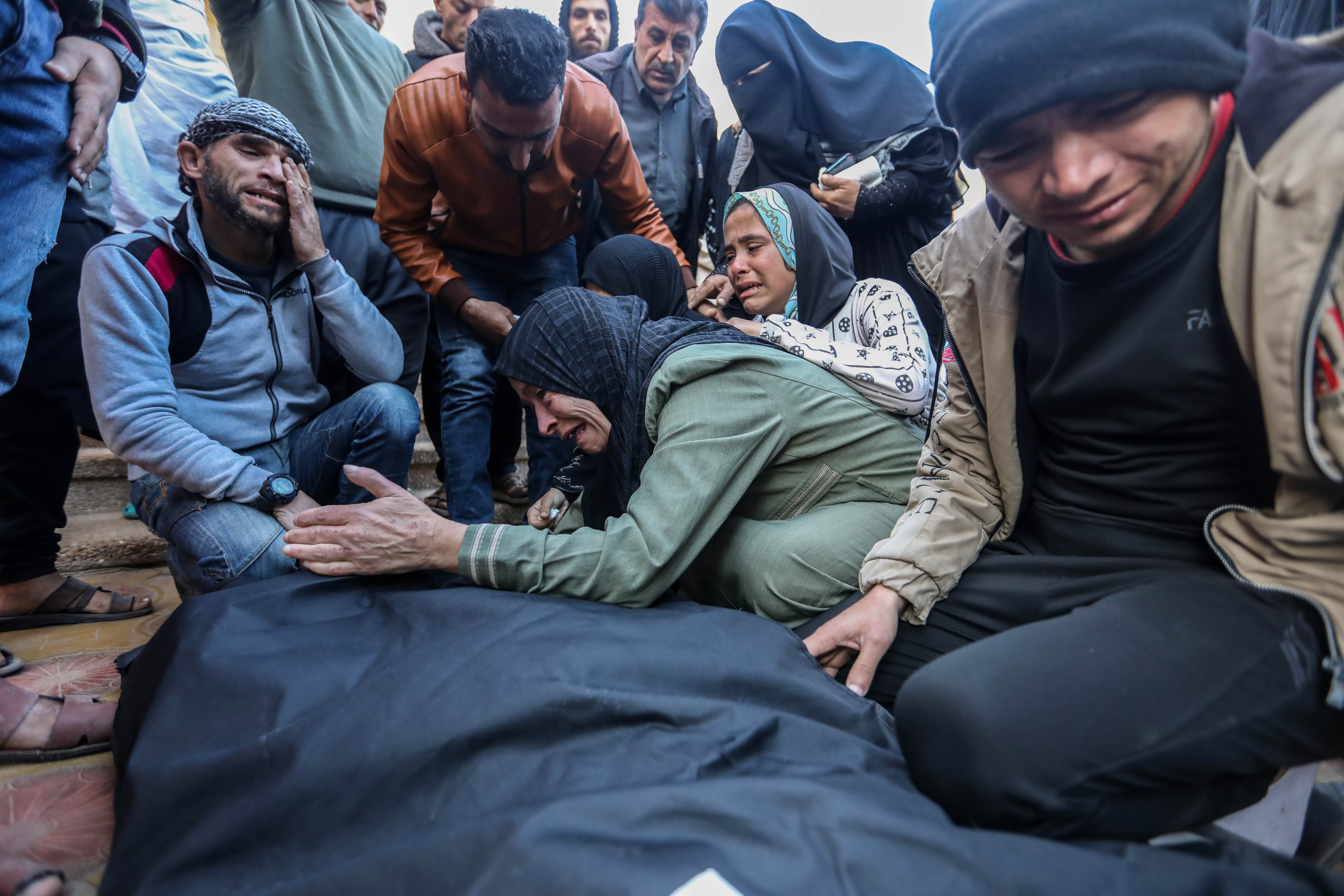 People mourn as they collect the bodies of Palestinians killed in an airstrike