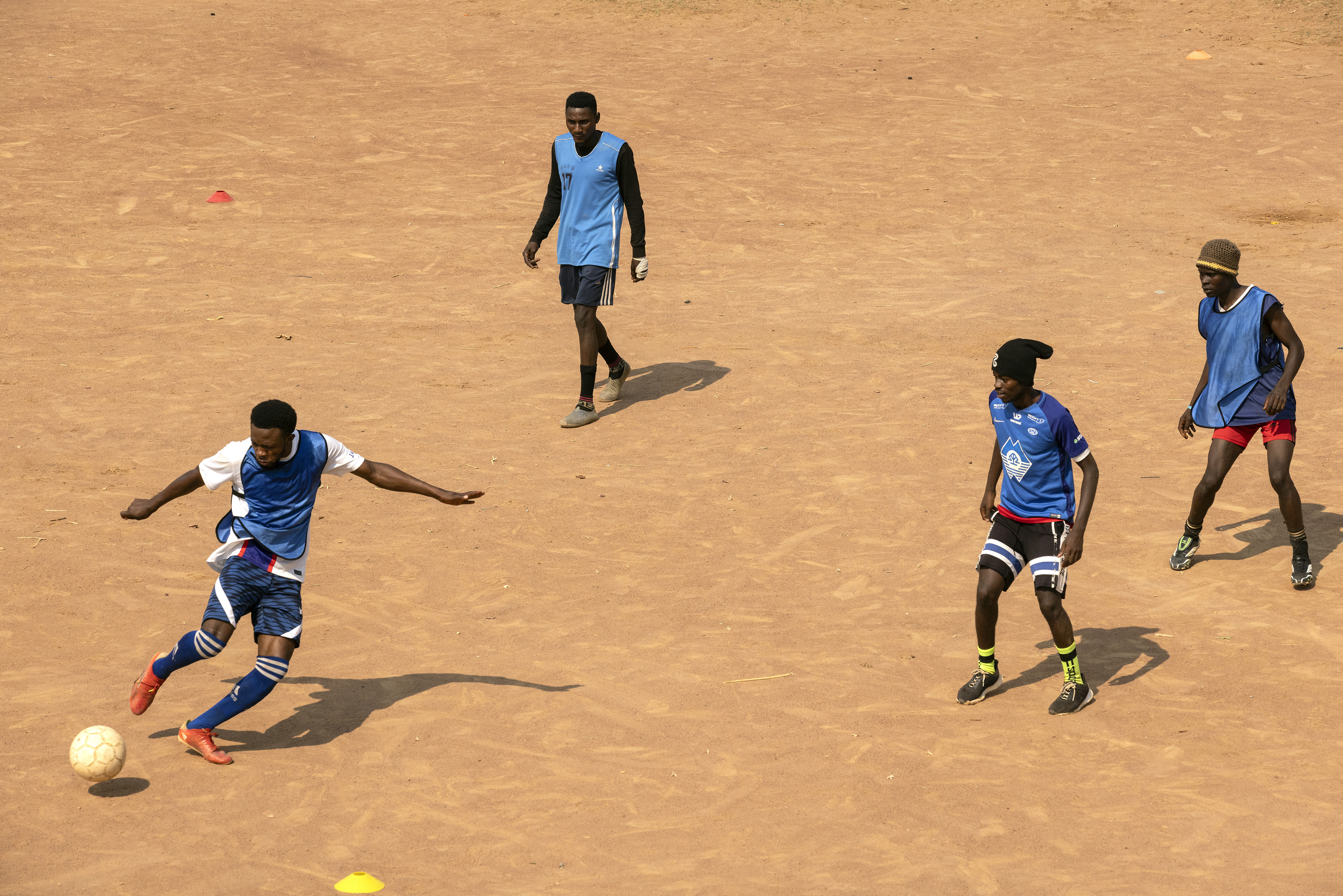 Football players on a field in a refugee camp in Zambia